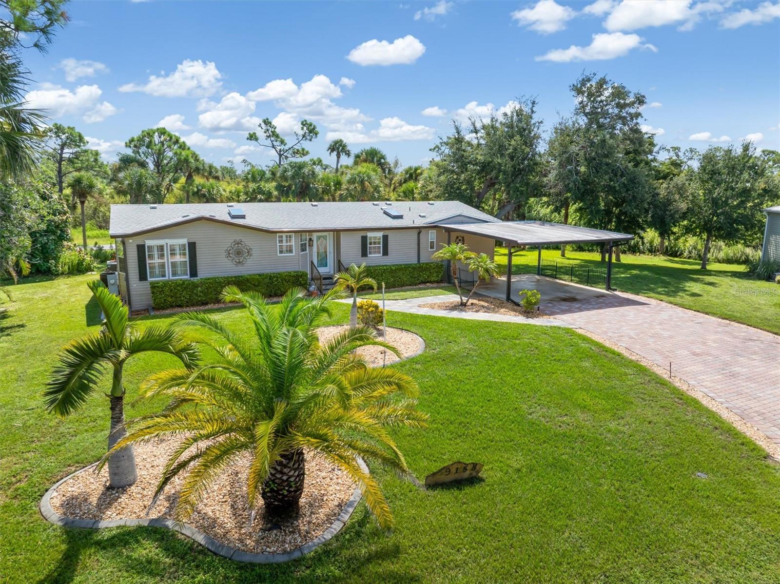 Welcome to The Pines at Sandalhaven in lovely Englewood, Florida , a 55+ deed-restricted, pet-friendly manufactured home community where you own the land with no lot fees.
This fantastic 2005 Jacobsen double-wide home offers 1,900 square feet of living space and sits on a rare large double lot, complete with a heated saltwater pool featuring LED lighting and an automatic pool robot vacuum. The home includes two bedrooms, two bathrooms, a spacious bonus room, and a two-car carport. A brick paver driveway and slate-tile walkway lead you to the inviting front entry. Inside, you’ll immediately forget everything you thought you knew about manufactured homes. The entire home is dry-walled with vaulted ceilings and finished with wide plank-ceramic tile flooring, and berber carpet.
Recent updates include a brand-new roof in 2023,and HVAC in 2019, microwave in 2018, critter guard in 2018, and half vapor barrier replaced in 2019. The gourmet kitchen is open and modern with ample oak cabinetry, a breakfast bar, and skylights that fill the space with warm natural light. It also features a sleek appliance package with black and stainless steel finishes, blending style and function. The kitchen flows into the main living area, which is lined with windows accented by plantation shutters and opens to the lanai and pool through sliding glass doors.
The primary suite offers a walk-in closet and French doors opening to the master bath, designed with a garden tub, dual sinks, a tiled shower, and a bright, light-filled atmosphere. The guest bedroom and guest bath are spacious, and the bonus room provides flexible space for an office, den, or overflow guests.
The highlight of this home is the expansive lanai and heated saltwater pool with LED lighting and an eight-foot deep end, all within a recently rescreened enclosure, creating the perfect private oasis. The large double lot provides extra privacy, while lush landscaping and visiting Florida wildlife bring nature right to your doorstep. A 16x12 shed offers excellent storage and workspace.
Residents of The Pines at Sandalhaven enjoy a clubhouse, heated community pool and spa, organized activities, and beautifully maintained grounds perfect for walking and biking. All of this is tucked away in a peaceful, private setting, yet only a short drive to three pristine beaches, shopping, dining, and the scenic trail along Placida Road.
This home captures the best of Florida living — privacy, nature, community, and convenience — all in one.