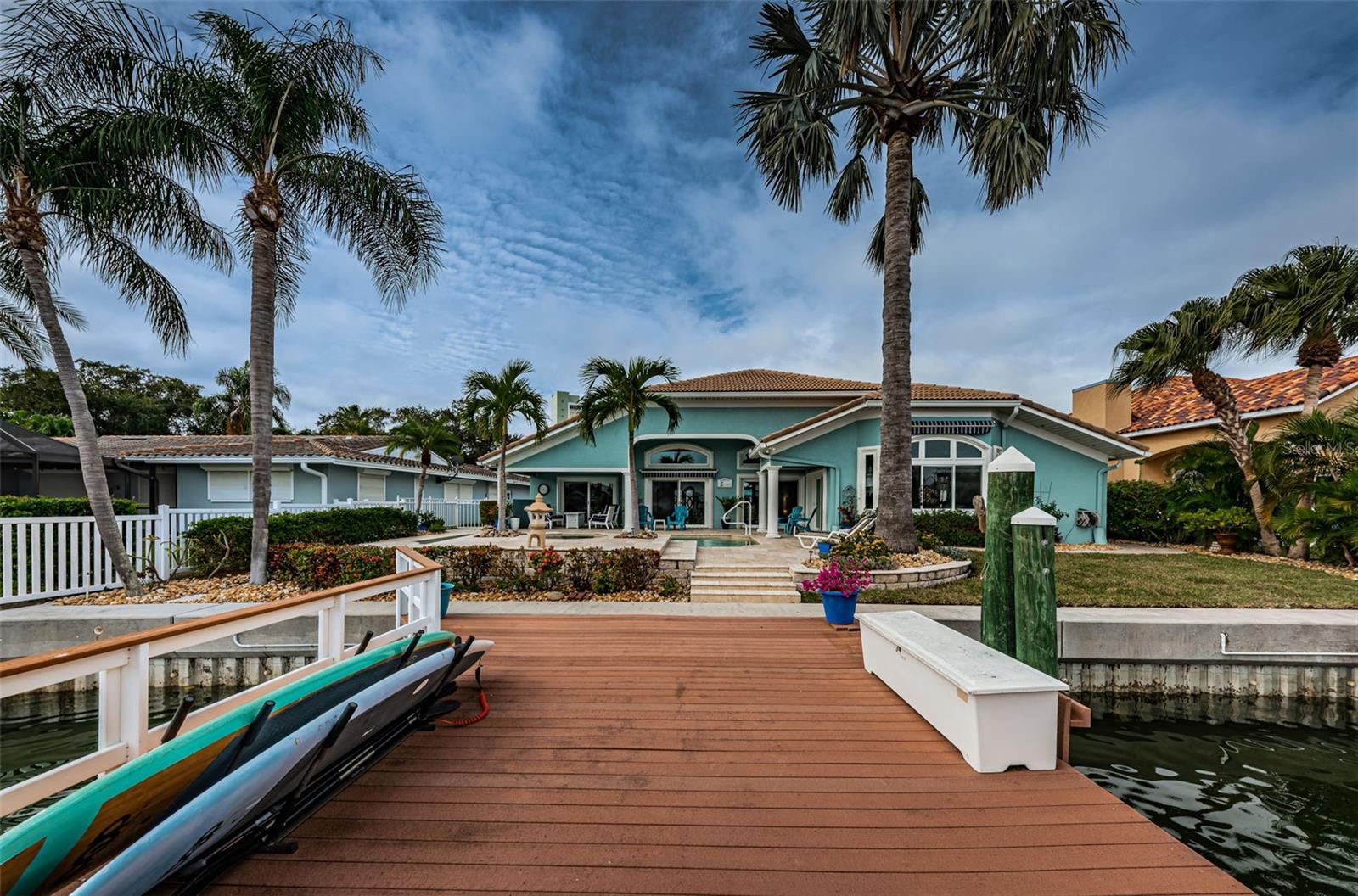 A stunning Waterfront Home located in the desirable Island Estates of Clearwater Beach ! You will capture glorious sunrises and sparkling water views in this beautifully updated tropical paradise home. You will be greeted at the entrance with custom leaded glass entry doors. The dramatic foyer has pillars and the residence was redone with vaulted ceilings throughout. The chef's kitchen features granite, newer stainless appliances, wood cabinetry and oversized custom windows, flooding this room with light. “all” the windows and glass doors are “Miami-Dade” rated – “impact glass” ! The home has been designed with an open concept floorplan including a grand living room and dining room space leading to wall to wall sliding glass doors opening out to your private tropical oasis. Custom built with relaxation and a casual elegance; you will love the volume ceilings - crown moldings - wide baseboards all accenting the sleek porcelain tile flooring. Add to this, a tastefully updated master retreat with an oversized walk-in closet and custom built-in cabinetry. The master bath has a wall to ceiling tile, walk-in shower, double sinks, granite countertop and separate water closet. The master also has built-in window seating to enjoy a good book, and outstanding views! You are going to love this waterfront setting with it’s heated, pool accented with a waterfall spa ! Two more bedrooms, a home office or 4th bedroom and 2 more full-baths in a split-plan configuration enhance the desirability of the home. Entering the backyard, you have a boater’s paradise with a wide canal. The very large composite dock with deep water can accommodate up to 3 vessels and has a, 13,000lbs. Lift as well as a, 6,000lbs. Jet-ski lift ! This home is truly a seaside sanctuary. Located on island estates, this waterfront home offers a perfect blend of luxury, functionality, and a serene coastal lifestyle. It's likely to be an ideal retreat for those who appreciate both the beauty of the indoors and the tranquility of waterfront living.