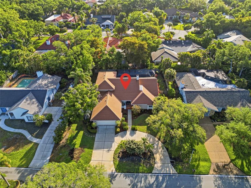Soaring ceilings and an abundance of natural light define this spacious 4-bedroom, 4-bath residence, thoughtfully designed and custom built by the original owner for both everyday living and effortless entertaining. Rich Cypress siding, elegant crown molding, plantation shutters, and imported Italian porcelain tile add warmth, architectural refinement, and timeless style throughout the home. The open floor-plan creates a seamless flow between living spaces, while a striking floor-to-ceiling white brick wood-burning fireplace serves as a dramatic focal point in the great room. Clerestory windows and skylights enhance the bright, airy ambiance, and custom built-in cabinetry compliments the home's clean, coastal-inspired design. Step outside to a private pool with an inviting setting for relaxing or hosting guests. A flexible office/den provides the ideal space for working from home or enjoying a quiet retreat, while generously sized bedrooms ensure comfort and privacy for family and visitors alike. Located within The Landings, a highly sought-after and gated West-of-Trail community, residents enjoy a lush, park-like environment with mature landscaping, scenic walking trails, and access to the Intracoastal Waterway. Community amenities include a kayak launch, kayak racks (as available), and a fishing pier situated at the end of a scenic nature trail, perfect for embracing Sarasota's waterfront lifestyle. Optional membership to the Landings Racquet Club offers tennis courts, a fitness center, clubhouse, and a vibrant social calendar. Ideally situated just minutes from downtown Sarasota, fine dining, shopping, and the world-renowned beaches of Siesta Key, The Landings offers an exceptional blend of privacy, natural beauty, and active living.