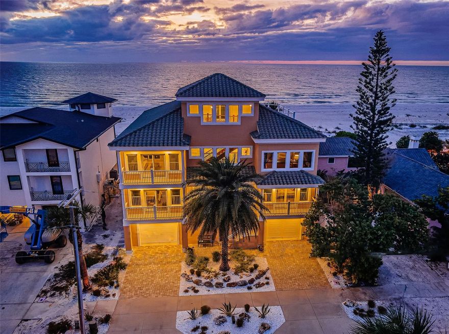 LOCATED DIRECTLY ON THE GORGEOUS WHITE, POWDER-SOFT SANDS OF NORTH CLEARWATER BEACH, THIS DAZZLING 4 BEDROOM, 5 BATH, BEACHFRONT ESTATE PROVIDES AN IMPRESSIVE 8592 TOTAL SQFT UNDER ROOF. Built of all block construction with hurricane impact windows and doors, you will appreciate the sturdy peace of mind this home has to offer. A soaring 20ft-high entry foyer introduces a home with lovely high ceiling and unforgettable views of the Gulf. An inspiring great room plan delivers panoramic views of the beach with terrific custom woodworking and tile/wood finishes. Magnificent18ft-high waterfront living area and separate sitting area with fireplace are supported by a huge luxury wetbar with extensive bar seating. The sumptuous gourmet chef’s kitchen boasts elegant granite surfaces, exceptional cabinetry, gas cooking, dedicated beverage chiller, offset undercabinet/counter lighting, and a mammoth island breakfast bar/prep center. Step out to the 450sqft dining/lounging deck and take in sweeping views of the beach/Gulf. The wonderful family room, with towering wood beam vaulted ceilings, is a great space to congregate or get away. The massive owner’s suite features fine recessed tray ceilings, superb hardwood flooring, a separate, generously-sized sitting room (with both areas opening to a huge 40ft-wide covered beachfront balcony with 180-degree views of the beach/Gulf), and an expansive his & her walk-in closet system. The owner’s bath enjoys its own views of the Gulf and includes exquisite tilework, splendid custom cabinetry, dual vanities, a dedicated cosmetics center and a poshly-appointed walk-in glass shower enclosure. All bedrooms are oversized and en suite, with private balconies, rich closet systems, and lavish full luxury baths. Your spacious lower-level entry area transitions to a dynamic outdoor playground; a 750sqft covered lower-level travertine deck contains a striking dining and lounging area, and a remarkable granite and tumbled-stone outdoor gas cooking center/kitchen with plush seating bar. Beyond the covered deck, discover a travertine deck that encases a stunning, partially-covered heated pool/spa with salt-chlorine conversion system. Your beach front is true bliss; resting well north of Clearwater Beach, you will appreciate the solitary, isolated appeal of this area. Not to be outdone, your deluxe 4-stop elevator will take you to a top-level observation deck with miles of unobstructed views of the Gulf, and the shorelines of Caladesi Island and Honeymoon Island. Gas hot water heating, water softening system, quality window treatments, exceptional wood ceiling finishes, fabulous guest bath with jetted Jacuzzi, spacious laundry with plentiful storage, and many, many extras. This is what Florida Beachfront living is all about! An extraordinary home in a premier, highly-sought-after location. Dimensions are estimates, buyer to verify.
