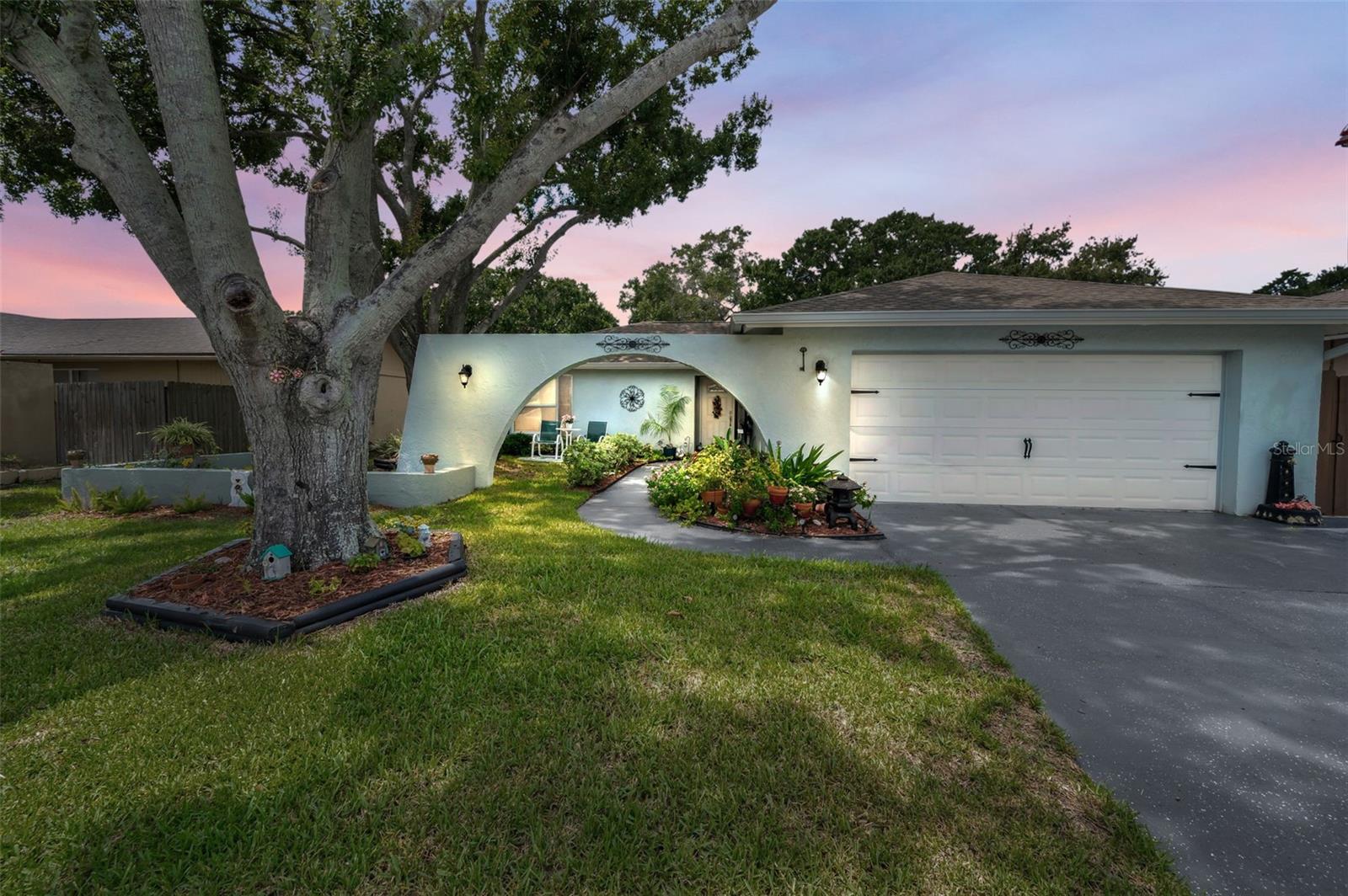 Welcome to this beautifully updated 3 bedroom, 2 bathroom home with an oversized 2-car garage in the heart of Palm Harbor! Located in a quiet community with NO HOA, NON flood zone, and zoned for top-rated Palm Harbor University High School, this home checks all the boxes. When you drive up you'll notice the curb appeal with lush landscaping and plants. Step inside to find brand-new laminate flooring flowing nicely all throughout the main living areas and kitchen, plush carpet in the bedrooms, and updated ceramic tile in both bathrooms. New modern light fixtures add a fresh touch. The spacious master suite offers an en suite bath with a double vanity with updated faucets and plenty of storage underneath. Two additional spacious bedrooms share a large second bathroom, also featuring a double vanity with updated faucets. The kitchen is perfect for everyday living with granite countertops, wood cabinetry, stainless steel appliances, and a breakfast bar. Sliding glass doors open to a large screened lanai with custom pull-down shades to keep the heat out on hot days, and a hot tub, ideal for relaxing or entertaining. Outside, enjoy a fully fenced backyard with beautiful lush landscaping, a pergola with cover for more space and entertaining, and plenty of privacy. The fence was stained giving it a unique look. Other updates include new plantation shutters in the primary bedroom and back bedroom. You can have all of this, plus being walking distance to shopping, dining, and entertainment. With its unbeatable location, updates, and desirable features - NO HOA, NON FLOOD ZONE, zoned for TOP RATED schools, this home is a must-see. Schedule your showing today!