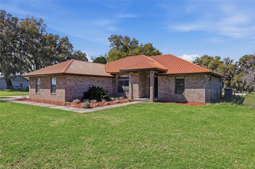 Escape to the peaceful charm of country living with this beautifully updated 3-bedroom, 2-bathroom brick home with a pool, perfectly situated on over 10 picturesque acres along a paved road. Surrounded by mature oak trees and serene views, this property offers privacy, space, and modern upgrades all in one. Step inside to find new flooring, renovated bathrooms, and brand-new appliances, along with a NEW HVAC system and NEW copper metal roof, giving you peace of mind for years to come. The spacious living room features sliding glass doors that open to a covered back porch overlooking the solar heated salt water pool—the perfect place to relax, entertain, and take in the beautiful countryside views. The home offers a thoughtful split floor plan, with the private primary suite on one side and the additional bedrooms on the other. The primary bathroom features a large soaking tub, ideal for unwinding after a long day. The spacious kitchen provides ample cabinet storage, along with a formal dining area, eat-in kitchen space, and bar seating, making it perfect for gatherings and everyday living. Outside, the property truly shines with a massive enclosed barn with bays, plus an attached garage and carport, offering plenty of room for equipment, hobbies, animals, or all of your recreational toys. The fenced acreage provides endless opportunities for farming, homesteading, or simply enjoying wide-open space. If you’re looking for peaceful, private country living with modern upgrades and room to roam, this exceptional property is a must-see.