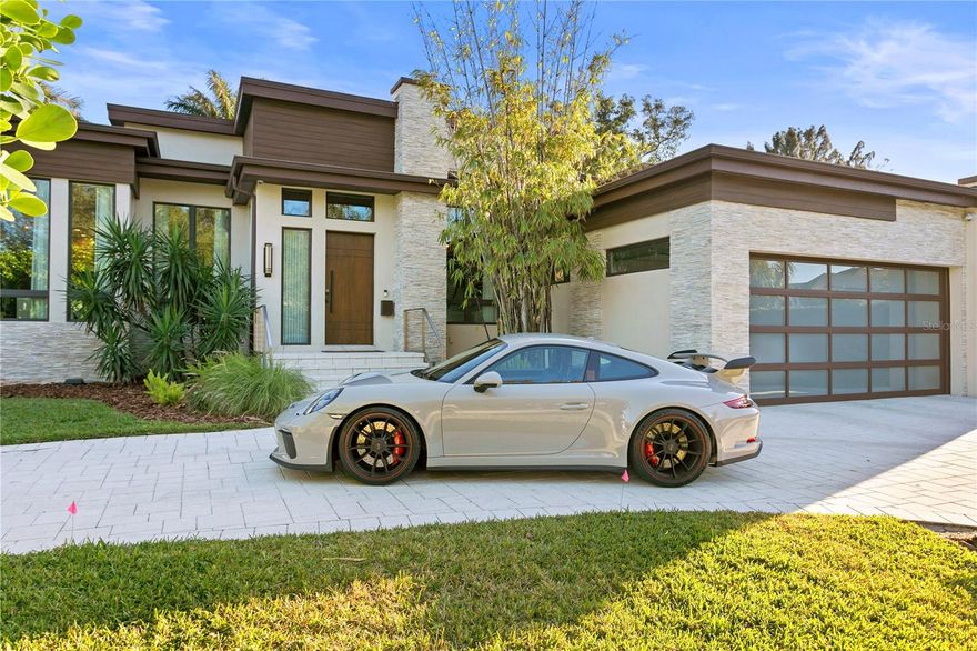 Immerse yourself in the lap of luxury within this one-of-a-kind single-story modern marvel, nestled in the prestigious Snell Isle Brightwaters enclave of St. Petersburg. Every detail of this residence has been meticulously curated to fashion an inviting and opulent ambiance. Upon arrival, the cove-lit great room beckons, bordered by expansive disappearing glass doors that seamlessly connect the interior to an outdoor sanctuary featuring a captivating pool and patios. At the heart of the home lies the open-concept chef's kitchen, a marvel designed for entertainment, boasting a 13-foot quartz waterfall island with seating for seven. Culinary wonders await with top-of-the-line Thermador appliances, including columnar wine units, freezer and refrigerator units, a 48-inch gas cooktop, steam and built-in ovens, and a Miele coffee station. Stylish functionality is further enhanced by a walk-in pantry.
Step outside to discover multiple water features and an infinity-edge spa, complemented by a striking covered outdoor kitchen. This al fresco haven includes a double gas fireplace, gas grill, refrigerator, sink, and a pass-through to the indoor kitchen. An additional seating area with a TV and fireplace elevates the entire outdoor setting, creating the perfect atmosphere for entertainment or relaxation.
The luxurious master retreat is a true sanctuary, opening to the pool areas and showcasing a spectacular shower, soaking tub, dual vanities, and two walk-in closets with custom cabinetry. Two additional bedroom suites feature designer baths and custom closets, ensuring comfort and style throughout the home.
The office, located off the foyer, exudes sophistication with custom 10-foot wood/bronze & glass barn-style doors. The powder bath is a work of art, boasting a vanity crafted from a tree removed during the property's transformation.
Additional amenities include a Sonos stereo system with 13 speakers, an all-house generator, and PGT hurricane impact windows, doors, and sliders, seamlessly combining luxury and security. Solar panels have been added to this ultra-modern home to enhance efficiency. This residence stands as a true masterpiece, offering a fusion of modern design, thoughtful functionality, and upscale living in the heart of Snell Isle. Don't miss out—schedule your appointment to view today!