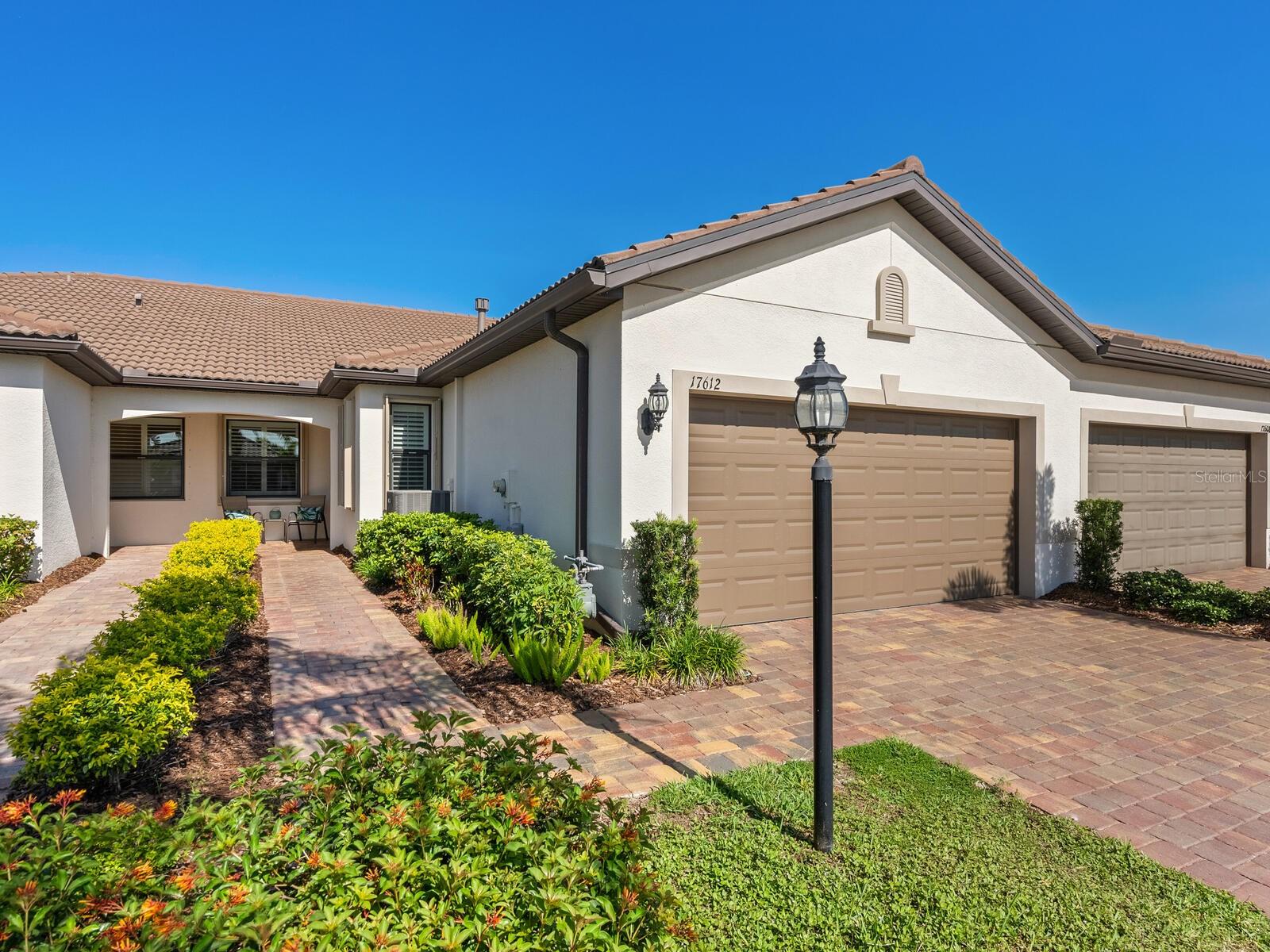 This beautifully upgraded villa was designed with the active adult in mind. The thoughtfully appointed Seagrove model villa offers a balance of comfort, convenience and luxury living in the desirable Del Webb at Lakewood Ranch community. This attached paired villa features two bedrooms, two baths, and a versatile den/flex room, providing approximately 1,458 square feet of living space. The open-concept layout features a spacious gathering room with expansive sliding glass doors that seamlessly connect to the screened-in lanai, creating an ideal indoor-outdoor living experience. The gourmet kitchen is a chef’s dream, complete with stainless steel appliances, generous counter space, white cabinets and stylish finishes, ideal for everyday living and effortless entertaining. The private primary suite, off the family room, is a retreat with a large walk-in closet and an elegant en-suite bath featuring dual sinks and an oversized walk-in shower with decorative tile. A generously sized secondary bedroom sits adjacent to the guest bathroom, which boasts a glass-enclosed walk-in shower and vanity with quartz countertop. The flex room adds valuable space, ideal as a home office, media room or hobby area—currently used as a media room with guest accommodations. The oversized two-car garage includes epoxy flooring, a utility sink and a tankless water heater for added efficiency. The owner has invested nearly $30,000 in thoughtful upgrades, including permanent exterior storm shutters, elegant plantation shutters, Blink doorbell and security cameras, epoxy garage floor coating, glass shower enclosures and more. Living in Del Webb at Lakewood Ranch means enjoying a vibrant, resort-style lifestyle. The community offers a 21,000-square-foot clubhouse, state-of-the-art fitness center, movement studio and dedicated activity rooms. Outdoor amenities include a heated resort-style pool and spa, tennis, pickleball and bocce ball courts, along with walking trails, a fire pit and an event lawn. A full-time lifestyle director ensures a packed calendar of social events, clubs and activities, making it easy to connect with neighbors who share your interests. Whether you're relaxing at home or taking advantage of everything this dynamic community offers, this villa is the place to live the lifestyle you’ve been dreaming of.
