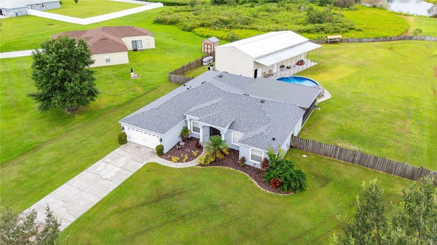 Approved 2.25% assumable VA loan (buyer must meet criteria and qualify in order to take advantage). Seller will contribute $5,000 towards buyers closing cost. Welcome to the quiet, GATED community of Avondale Groves. Nestled on nearly 2 acres of peaceful, open land, this spacious 4-bedroom, 3-bathroom home offers the perfect blend of comfort, function, and freedom. Whether you're entertaining guests, working from home, or simply soaking up the quiet, this property delivers. Inside, you'll find a well-designed layout featuring a dedicated office/den ideal for remote work, hobbies, or a quiet reading space. The open concept flows effortlessly, connecting your living, dining, and kitchen areas for easy living. Primary bedroom features walk in closet and bathroom with dual sinks. Split bedroom floor plan with bedrooms 2 & 3 Jack & Jill style. 4th bedroom tucked in the back along with the 3rd bath making this the perfect space for guests. Kitchen equipped with upgraded GRANITE countertops and stainless steel appliances. Outside you will be greeted with a large covered/screened patio that leads you straight out to the above-ground pool perfect for cooling off during Florida summers. The 65x30 detached RV GARAGE/WORKSHOP is a rare find, fully equipped to house an RV with 30/50 AMP electrical and offering ample storage space including a climate-controlled storage room for added convenience. Home is wired for an emergency generator. The property line covers roughly 3/4 of the pond which is stocked,  ready for  fishing. This home has it all space, privacy, utility, and comfort. Don't miss this unique opportunity to own a one-of-a-kind property that checks every box. UPDATES INCLUDE- New DOUBLE ENTRY DOORS, New ROOF, New WATER HEATER Aug. 2025,  FRESH INTERIOR/EXTERIOR PAINT, DISHWASHER 2025, POOL LINER 2025, POOL PUMP April 2024, GRANITE in kitchens & bathrooms and WATER SOFTENER 2022. Garage fridge, both sets of W/D to convey USDA eligible. Schedule your showing today!