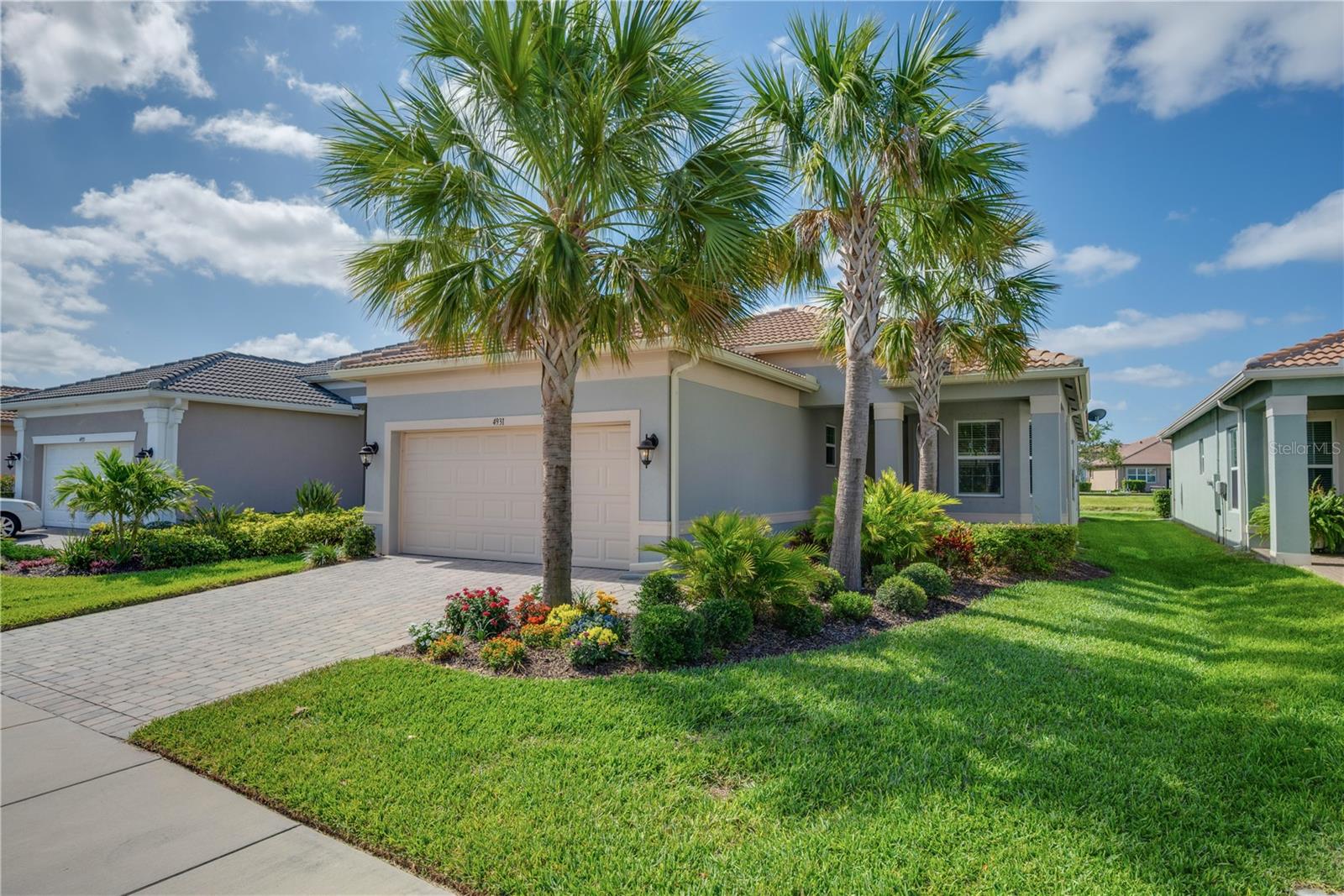 Turnkey Furnished Home with tranquil Water View in Valencia del Sol – Premier 55+ Resort Community. Located in the heart of Valencia del Sol, Tampa Bay’s most exciting 55+ resort-style community, this beautifully upgraded Capri model offers the perfect combination of comfort, elegance, and carefree living. Designed for those who want to embrace an active lifestyle without sacrificing luxury, this fully furnished home is move-in ready and showcases a serene southern-facing water view. From the moment you arrive, you'll notice the home’s incredible curb appeal, featuring a charming covered front porch, brick paver driveway and walkway, bay window, and elegant double 8-foot glass entry doors. Inside, the open-concept design connects the great room, kitchen, and dining area, creating an ideal layout for entertaining or simply enjoying the flow of everyday life. The spacious great room features triple 8-foot sliding glass doors that lead to a covered, screened lanai where you can relax and take in peaceful water views year-round. The gourmet kitchen is a true showstopper, offering upgraded 42-inch maple cabinets with crown molding and under-cabinet lighting, Silestone quartz countertops, a large peninsula with counter-height bar seating, and stainless steel appliances including a GE slide-in gas range and French-door refrigerator. A designer tile backsplash, undermount stainless sink, soft-close drawers, built-in pantry with pull-out shelves, and double trash pull-out add both beauty and function to this exceptional culinary space. Large porcelain tile floors laid in a waterfall pattern flow throughout the main living areas and den, adding to the home's modern yet timeless appeal. The spacious primary suite features a coffered ceiling and two oversized walk-in closets. The primary bathroom is a luxurious retreat, complete with separate vanities, quartz countertops, a walk-in shower with built-in seat and ceiling-height tile, a built-in linen closet, and upgraded maple cabinetry. An oversized den with 2-panel solid French doors offers flexibility as a home office, media room, or optional third bedroom. The conveniently located laundry room includes upper cabinets for additional storage and comes equipped with a washer and dryer. This home is packed with high-end upgrades that enhance comfort and peace of mind, including a variable-speed air handler, recessed lighting, hurricane shutters, whole-house surge protector, sealed pavers, epoxy-coated garage floor, insulated garage overhead door, overhead storage rack, rain gutters, and a water softener pre-plumb. Offered fully furnished with stylish new office and lanai furniture, this home is truly turnkey—just bring your toothbrush and start enjoying the Valencia del Sol lifestyle today. With endless entertainment, a vibrant social calendar, and luxury amenities including a resort-style pool, clubhouse, fitness center, tennis and pickleball courts, and on-site café, Valencia del Sol redefines 55+ living on Florida’s Gulf Coast. Schedule your private showing today and make this stunning home yours.