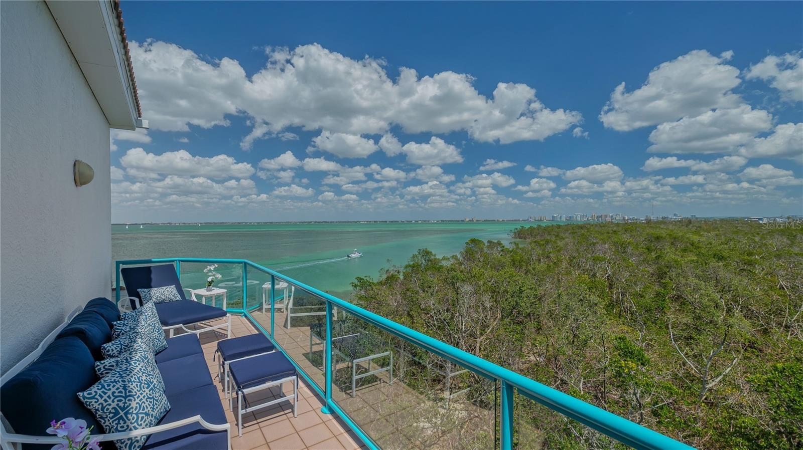 Two-level penthouses at Tangerine Bay Club are a rare offering, and this south-facing corner residence elevates the standard. Recently reimagined with refined sophistication, this nearly 3,000-square-foot getaway captures breathtaking panoramic views of Sarasota Bay, the city skyline, and lush coastal mangroves. Perfectly situated to ensure ultimate privacy with two coveted terraces and peaceful neighboring nature preserves. The exclusive layout lives like a single-family home, featuring private access through a private courtyard and a coveted two-car garage. Inside, coastal elegance meets thoughtful craftsmanship. The open-concept design has been curated with premium enhancements including impact-rated Andersen windows, motorized storm shutters, custom LED lighting, and California Closets throughout. A dramatic living room with vaulted ceilings and skylight is centered around a gas fireplace and built-in entertainment wall, while walls of glass frame picturesque bay views and open onto two expansive terraces, ideal for indoor-outdoor living. At the heart of the home, the gourmet kitchen impresses with top-tier finishes: honed marble countertops, a striking island with leathered stone, custom cabinetry by Campbell Cabinetry Designs, and chef-caliber appliances—including a La Cornue dual-fuel range with French plate, built-in Flamberge rotisserie oven, galley sink, wine cooler, and Sub-Zero beverage drawers. A dining nook and formal dining space offer versatile options for entertaining or casual meals. The primary suite is a peaceful retreat tucked onto the east wing. It offers terrace access, custom wardrobe systems, and a luxurious en-suite bath clad in quartz with a freestanding tub, double vanities, and walk-in steam shower. A second bedroom with nearby full bath is currently styled as a den, while upstairs, a lofted lounge with built-ins and third bedroom suite create an ideal space for guests or work-from-home flexibility. Tangerine Bay Club is a resort-style community known for its Mediterranean-inspired architecture, lush tropical landscaping, and premier location on Longboat Key’s southern end. Residents enjoy a long list of amenities: a 25-meter heated pool and spa on a private island, tennis and pickleball courts, fitness center, kayak launch, walking paths, vibrant social calendar, and a day dock (first-come, first-serve). Optional membership to the exclusive Bay Isles Beach Club provides deeded access to a private stretch of the Gulf’s sugar-white sand. Just outside the gates, enjoy proximity to world-class offerings including Longboat Key Club, Dry Dock Waterfront Grill, Chart House, and golf and marina access at Harbourside. A short drive brings you to the boutiques and fine dining of St. Armands Circle, and the cultural heartbeat of downtown Sarasota’s art galleries, theaters, and restaurants.