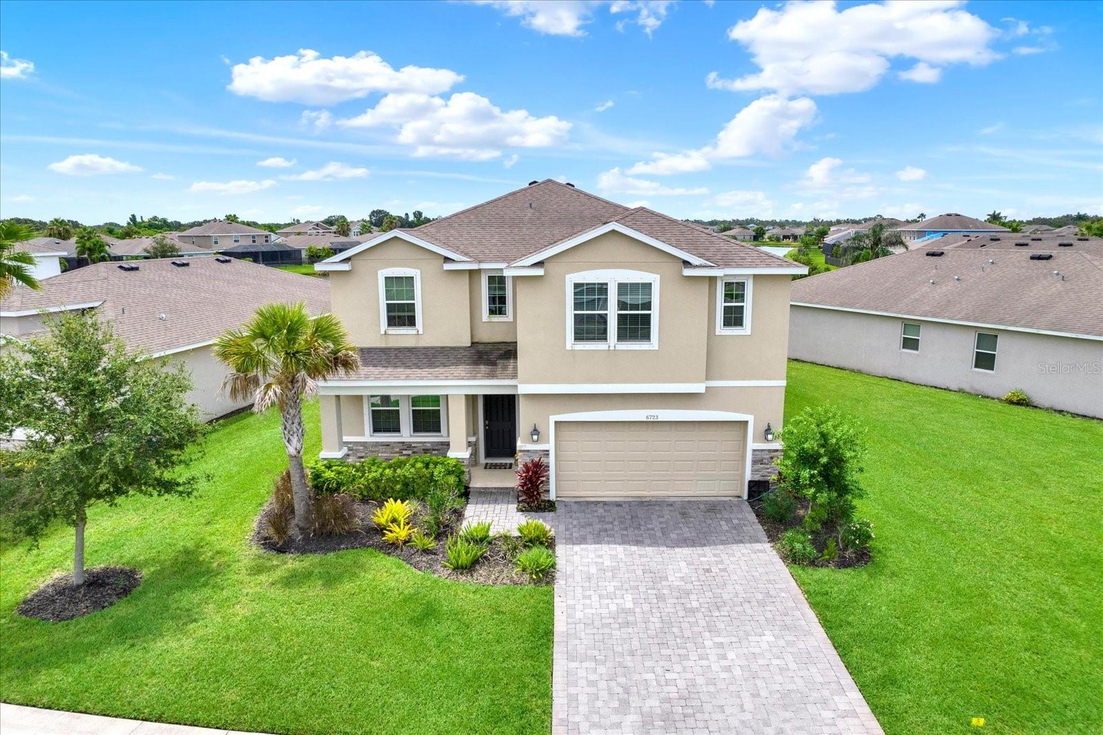 This expansive 5-bedroom, 4-bath home is the largest floor plan in Trevesta, offering a layout designed for comfort, connection, and flexibility.
Step inside to an open-concept kitchen, dining, and great room that flow seamlessly to a covered lanai-an inviting space for relaxed mornings, family dinners, or casual get-togethers. A full guest suite on the main floor provides privacy for visitors or multigenerational living.
Upstairs, the generous owner’s suite is a peaceful retreat, while three additional bedrooms surround a shared full bath. A versatile upstairs bonus living area offers endless possibilities-movie nights, homework stations, or simply a second spot to unwind. The upstairs laundry adds everyday convenience.
Set on a lake-view lot in a friendly, sidewalk-lined neighborhood, this home combines space, function, and a true sense of community. With access to Trevesta’s amenities and a thoughtfully designed layout, it’s a place where everyday living feels easy and intentional.