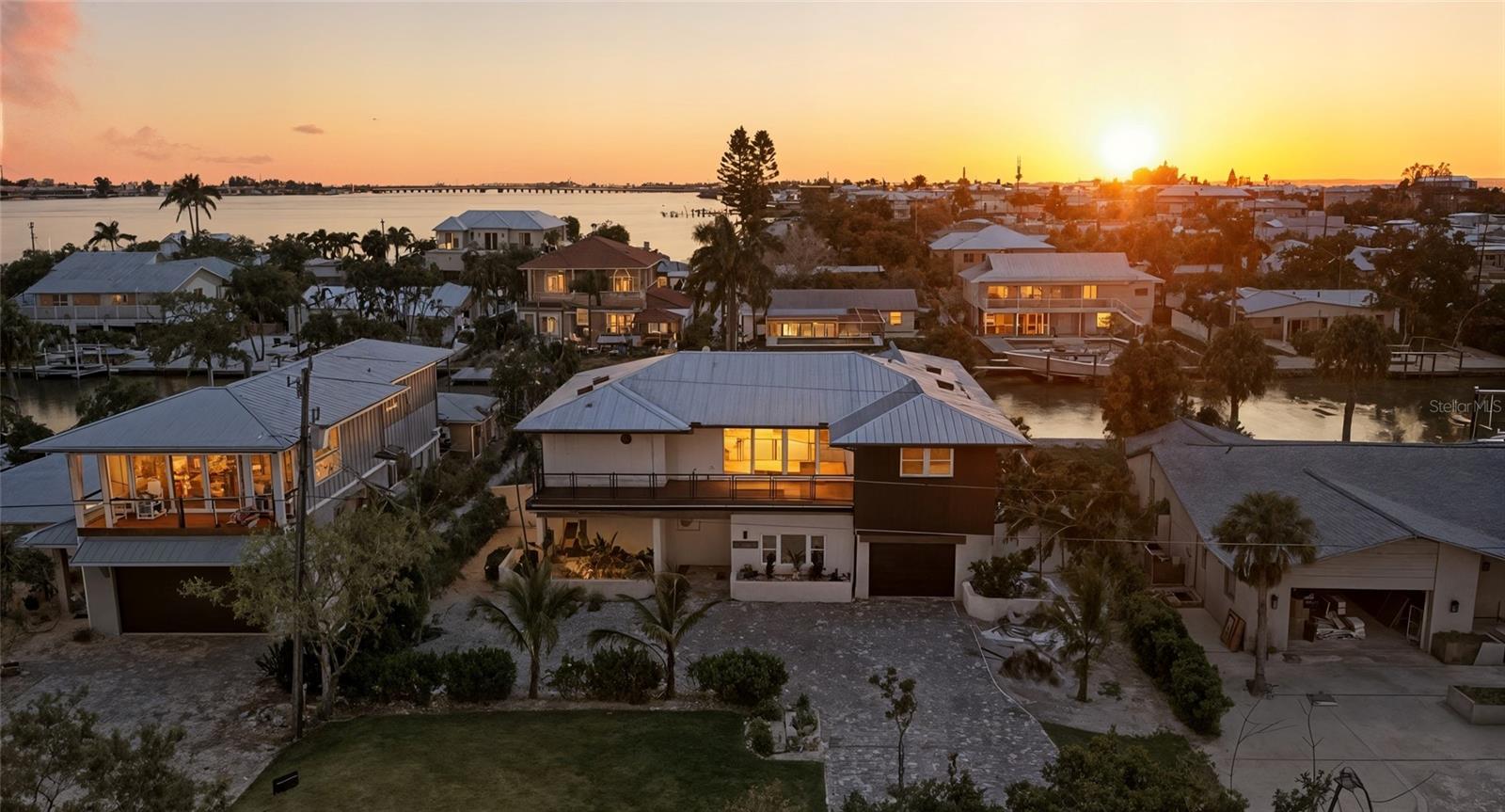 This newly renovated mid-century modern waterfront home on Anna Maria Island features nearly 80 feet of prime canal frontage, providing breathtaking views from almost every room of the property. A private boat dock and lift make this residence a paradise for boating enthusiasts, while also being only steps away from the beach. Step inside to discover a spacious open-concept living room with vaulted ceilings and two large balconies. A modern kitchen outfitted with high-end appliances, ample storage, and chic finishes overlooks your private pool and spa. The master bedroom features access to the back patio leading to the pool plus walk-in closet. The spa-like master bathroom centers around your stand-alone tub and frameless glass shower with dual his and her vanities. Recent renovations include electrical, plumbing, and air conditioning systems, impact-rated windows, new exterior siding, and a new metal roof, ensuring the home is both safe and energy-efficient. Schedule your showing today!