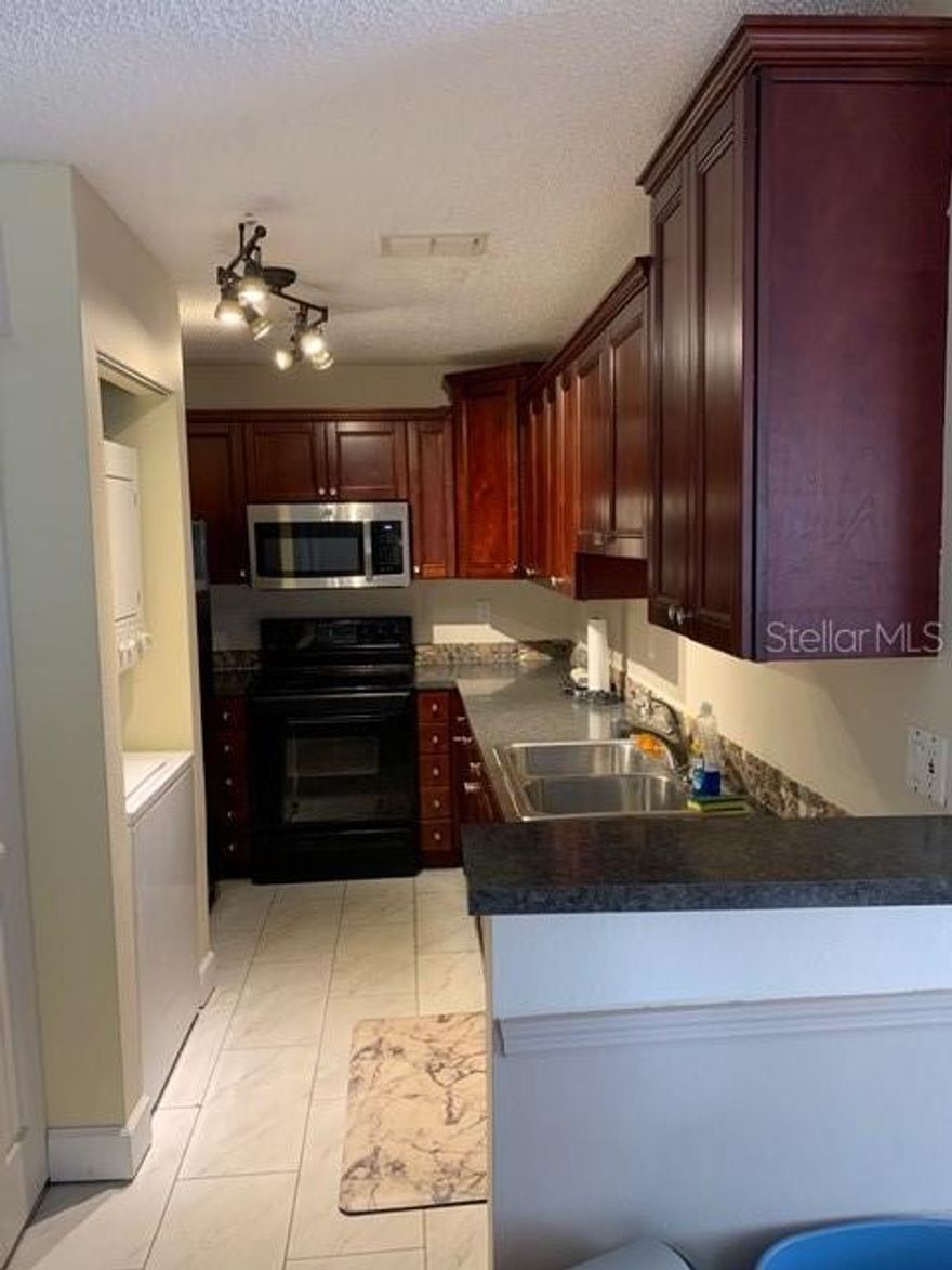 Super-cute first-floor corner unit condo just minutes from Walt Disney World, I-4, and SR-429! Welcome to the tucked-away and welcoming community of Palm Villas, where this well-located unit offers a fantastic view and an incredible opportunity—whether you’re looking for a primary residence or a short-term rental/Airbnb investment.

This spacious 3-bedroom, 2-bath condo features an updated HVAC system and beautiful wood flooring, found throughout all living areas. The open living and dining spaces flow seamlessly to a screened back patio with no rear neighbors, creating a private and relaxing setting.

The galley-style kitchen offers ample cabinet storage and workspace, while the primary suite, located just off the main living area, includes direct patio access and peaceful backyard views. The primary bathroom features a full tub/shower and a convenient owner’s closet.

Two additional bedrooms are located near the second full bath, including an oversized 11 x 19 bedroom with its own owner’s closet. Both bathrooms and the kitchen include upgraded laminate flooring with stylish grout accents.

Residents enjoy access to a community pool and tennis courts, and each unit includes an assigned parking space with additional guest parking available.