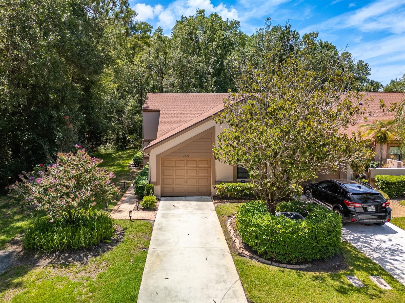 Desirable Brookhaven, a GATED Community in Ridgemoor offering Maintenance Free Living in the Heart of Palm Harbor! This End Unit Villa is located on a Beautiful Wooded Lot with 3 Bedrooms (3rd Bed could be used as Office/Den), 2 Baths, 1 Car Garage & offers Crown Moldings, Vaulted Soaring Ceilings offering Peaceful Wooded Views! Beautifully Updated Kitchen with Eat-in Nook, Coffee Bar, Glass Top Range, Stainless Steel Appliances, Granite Countertops, Decorative Backsplash, Undercount lighting & wall of cabinets. Great Room Floor Plan with Wood-like Flooring & Dining area features Custom Stacked stone Wood Burning Fireplace with mantel & Sliders to the Expansive Covered & Screened Patio/Deck. Master Suite with Crown Molding & Wood-like Flooring features En-suite Bath with Step-in Shower & Vanity. At the front of the home is the 2nd Bedroom with an adjacent Bath featuring Newer Vanity & Tub/shower. Double Doors into the Third Bedroom with Built-in shelving for Closet (currently being used as an Office). Sliders lead to Covered Patio & Expansive Open Deck with Tranquil Private Views of Nature & Wildlife. HOA $329.93 month (Brookhaven) + $75 month (Ridgemoor Master) $180 annual (Farrell Park/Brookhaven) includes Ground Maintenance, Painting of Exterior, Community Pool, Tennis Courts, Playground, Picnic area & Walking Trails. Pet Friendly Community & Super Location close to John Chestnut Park with a Variety of Wildlife and Lake Tarpon for Boating & Dog Park, N Pinellas Trail and YMCA, Shopping, Restaurants, Golf Courses Nearby. Short drive to the Beach, Tampa International Airport & PIE Airport. Easy Commute to Tampa and St. Pete. A/C 2020. Water Heater 2023. NEW Roof 2024. New Duct work 2025.