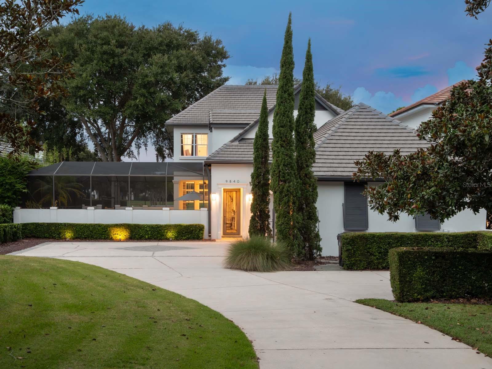 This private, tucked-away residence is perfectly located on the front nine of Lake Nona Golf & Country Club’s championship golf course. Thoughtful upgrades, an abundance of light-filled spaces and sensational sunset views distinguish this beautiful courtyard home. An expansive front yard, with mature landscaping and winding driveway, welcomes you into the screen-enclosed courtyard with a serene salt water, heated pool and spa. 
Elevated and updated finishes throughout the interior, including polished Italian travertine flooring, sleek light fixtures and custom tile selections, create a seamless integration of modern comfort and traditional beauty. The kitchen, sharing its space with an open dining area, features an oversized island with ample storage, elegant custom cabinetry and appliances by Wolf, SubZero and Bosch. A butler’s pantry with a wine fridge and storage is perfect for relaxing and entertaining alike. 
The first floor also includes a spacious owner’s suite with a spa-like bathroom retreat offering a freestanding tub, walk-in glass enclosed shower, with multiple spray options, and a large closet with ample shoe storage. The adjacent family room is anchored by a stunning entertainment wall, with fire place, and features French-door access to the covered lanai. 
A contemporary glass railed, lit staircase ascends to the second floor, which provides three bedrooms, including an additional owner’s suite. Accentuated by a convenient wet bar, the entertainment loft is flooded with natural light, and is in a prime location within the home. Opening to a rebuilt balcony, this room captures panoramic views of Holes #3, #4 and #5. Additional features include an outdoor grilling station, first floor laundry room and a three-car garage.