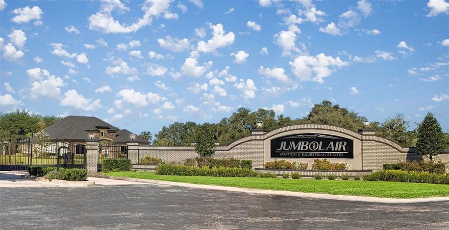 Premier End-of-Taxiway 4.10-Acre Lot in Jumbolair Aviation Estates. Nestled within the exclusive gates of Jumbolair Aviation Estates, this exceptional 4.10-acre vacant homesite offers a rare opportunity to build your custom estate in one of the nation’s most prestigious private aviation communities. Perfectly positioned at the end of a taxiway, this expansive parcel provides both privacy and direct access to the runway—an ideal setting for aviation enthusiasts seeking seamless fly-in, taxi-to-your-door convenience. This desirable homesite allows you the freedom to choose your own builder and bring your unique vision to life. The lot is mostly cleared, offering a head start on construction, while a scattering of beautiful mature oak trees provides character, shade, and natural charm. As a large corner parcel with access from two streets, the property offers the flexibility to position your home to face either street—enhancing both design possibilities and curb appeal. Surrounded by natural beauty, the property offers a serene, estate-sized setting with ample room to design a luxury residence, private hangar, and resort-style outdoor living spaces. The generous acreage allows for flexibility in layout while preserving the exclusivity and tranquility that define Jumbolair living. Residents of Jumbolair Aviation Estates get to enjoy a private 7,550-foot lighted runway capable of accommodating large aircraft, 24/7 security, and a close-knit community of like-minded aviation enthusiasts. Located just minutes from Ocala’s renowned equestrian venues, fine dining, shopping, and medical facilities, this property combines the best of luxury living with unparalleled aviation access. Whether you’re a pilot, collector, or simply seeking a prestigious and private setting to build your dream estate, this unique taxiway lot represents a truly extraordinary offering in one of Florida’s most distinguished aviation communities. Don’t miss your chance to own a premier piece of runway-accessible property in Jumbolair Aviation Estates—where lifestyle and aviation meet in perfect harmony.