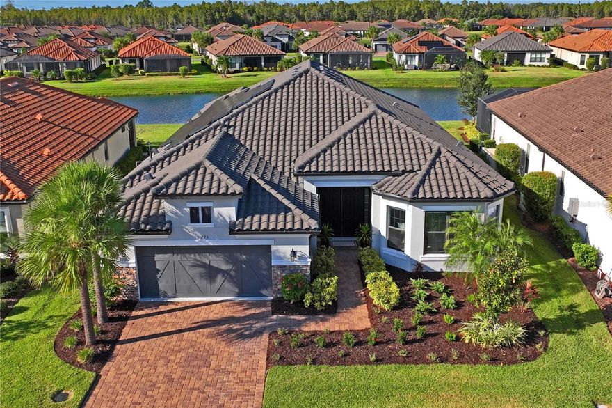 Ready for modern, energy-saving, upscale living? Welcome to your SMART and SOLAR ENERGY-EFFICIENT (Paying on average $30 a month for electric) home fully equipped with TESLA, OWNED 28 SOLAR PANELS AND EV CHARGER. This meticulously maintained, and beautifully designed Taylor Morrison PALLAZIO provides the perfect blend of comfort, modern elegance, and functionality. With $129K builder upgrades and $142K invested after, this 3 bedroom, 3 full bathroom, with DEDICATED DEN/OFFICE SPACE enclosed with CRYSTALIA SOUNDPROOF FROSTED GLASS PARTITION DOORS, is a standout in both design and livability. The spacious 4’ EXTENDED, 2-car garage comes equipped with $11k worth of built-ins perfect for keeping organized, FINISHED ATTIC FLOORING for STORAGE made easy with INSULATED STEEL LADDER. As you step inside, an open-concept layout is accentuated by MOHAWK LAMINATE REV WOOD SELECT FLOORING, NEUTRAL TONES, and timeless modern lighting and design selections. The GOURMET KITCHEN boasts QUARTZ COUNTER-TOPS, HIGH-END GAS APPLIANCES (with the OPTION for ELECTRIC), EXTENDED AMPLE CABINET SPACE with WINE FRIDGE and CASUAL DINING SPACE, CUSTOM BUILT PANTRY, and a spacious 10 ft. ISLAND perfect for entertainment. Adjacently, the living room features a STUNNING ACCENT WALL adding a true focal point that brings warmth and texture to the space. The home also provides a LUXURIOUS PRIMARY SUITE with 12 ft. WIDE WALK-IN SHOWER WITH, and EXPANSIVE WALK-IN CUSTOM BUILT CLOSET, while a PRIVATE JUNIOR SUITE provides comfort for guests or multi-generational living. The additional bedroom and full bath are ideally situated for maximum privacy and convenience with a POCKET SLIDER to convert into another PRIVATE SUITE. Enjoy the Florida lifestyle year-round from your COVERED and SCREEN ENCLOSED LANAI, overlooking WATER VIEW from backyard, surrounded by LUSH, TROPICAL LANDSCAPE. Entertain with ease using the PRE-PLUMBED FOR GAS OUTDOOR KITCHEN, complete for sink addition—perfect for weekend gatherings and sunset dinners. The home is equipped with 8 FT DOORS, 10 FT CEILINGS, MODERN WALL FEATURES, CUSTOM WINDOW SHADES, ROLLER BLINDS, BLACKOUT CURTAIN PANELS IN PRIMARY, MATTE ONYX HARDWARE and FIXTURES, LUTRON MOTION SENSOR LIGHT and DIMMER SWITCHES, TANKLESS WATER HEATER, HIGH-END LIGHTING & CEILING FANS, and LUXURY HOTEL INSPIRED BATH MIRRORS, TRAY CEILINGS, HURRICANE SHUTTERS, and a WHOLE-HOME WATER SOFTENER. HOA dues COVER ALL COMMUNITY AMENITIES, including clubhouse access, FITNESS CENTER, walking trails, HEATED POOLS AND SPA, FIREPIT, PICKLEBALL, TENNIS, and SHUFFLEBOARD COURTS, planned year-round community events, and so much more—along with COMPREHENSIVE LAWN MAINTENANCE, ensuring low-maintenance living. Plus, enjoy full access to all Starkey Ranch amenities including parks, pools, community garden, and recreational facilities. This home combines refined design with everyday practicality—ideal for those who appreciate thoughtful upgrades, modern convenience, and a vibrant, amenity-rich neighborhood. This exclusive gated community is strategically located near major highways for swift commute, shops, hospitals, local favorites, and much more. Whether you're looking to relax in style or entertain in elegance, this property delivers on every level. Don’t miss this rare opportunity to own one of the most beloved floor plan in one of the most desirable communities in the area. Schedule your private showing today and experience firsthand the exceptional lifestyle that awaits!