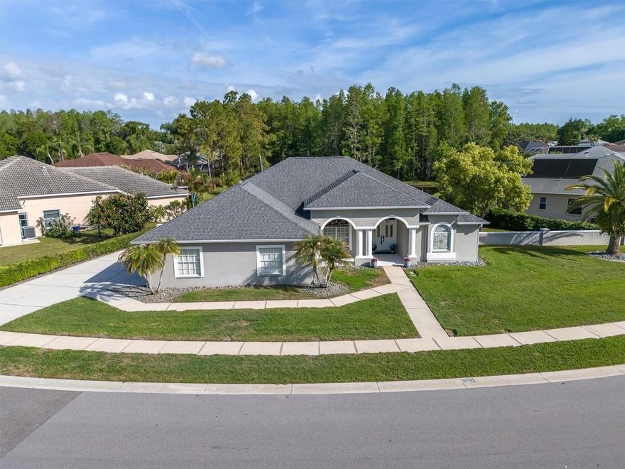 NEW PRICE - AMAZING VALUE - PRIVACY & TRANQUILITY in the HEART OF TRINITY. Don't miss this SPRAWLING ONE STORY HOME located on a .31 acre conservation pond view lot. Built by Samuelsen Builders, this highly sought after, perfectly designed tri-split floor plan features 4 bedrooms, 3 bathrooms, 3 car side load garage with 2634 square feet of living space. Just inside the double front entry doors you will notice ample natural light streaming in along with the newer porcelain tile floors that run throughout most of the home and the beautiful views from the formal living room pocketing sliding glass doors. To your left is a home office featuring double glass pocket doors, transom window  and floor to ceiling built in bookshelves with storage cabinets. Gather your family in the gourmet kitchen, the heart of the home. The chef-inspired kitchen is fully equipped for entertaining, featuring a center island, corian countertops, new stainless steel appliances, recessed and under-counter lighting, tile backsplash, closet pantry, a breakfast nook and breakfast bar with seating for 4 all overlooking the expansive family room. The family room features soaring ceilings, crown molding with pocketing sliding glass doors to the outdoor living spaces and pool, perfect for entertaining. The generous 14x18 primary suite retreat includes soaring ceilings, dual walk-in closets, and a large en-suite bathroom with a garden tub, walk-in shower, two separate vanities, private commode and a linen closet. Just off the family room are 2 secondary bedrooms and a bath that can be privatized with a conveniently located pocket door. The 4th bedroom and pool bath are located at the back of the home and can also be sectioned off by a pocket door.  Additional features of the home include NEST Thermostat, smart home features, high ceilings, crown molding, upgraded ceiling fans and light fixtures, large inside laundry room with a laundry sink and storage closet, solid wood doors, 800 sqft, oversized garage with pull down staircase for attic access and EV charging station, newer roof (2018), new interior and exterior paint (2020), water heater (2014), ring door bell with 3 outdoor security cameras, pre-plumbed for a water softener, central vac, lots of storage closets & cabinets and a fenced-in yard with a rainbird irrigation system. Enjoy true Florida living on the sprawling covered lanai, overlooking the pool complete with a small outdoor wet bar area with convenient access from most rooms, the home is perfectly designed for entertaining as well as everyday enjoyment.  LOW annual HOA dues and NO CDD fees is another reason to love this community. This HIGHLY SOUGHT AFTER TRINITY OAKS COMMUNITY HAS A PLAYGROUND & WALKABILITY to TOP RATED SCHOOLS. It is near golf courses, Starkey/Suncoast/Pinellas Trails, JW GILLS YMCA, shopping, restaurants, medical facilities, the TRINITY COMMUNITY PARK WITH DOG PARKS and PICKLEBALL COURTS and a NICE WALKING TRAIL AROUND A BEAUTIFUL POND all with easy access to Tampa International Airport, St. Pete/Clearwater International Airport, cultural centers, beaches and so much more. MUST SEE~