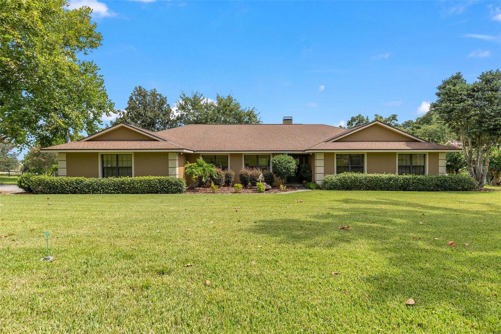 Peaceful Living in the Heart of Central Florida’s Golden Triangle
Welcome to your private retreat on 2.3 acres in one of Central Florida’s most sought-after locations. Perfectly nestled between the charming towns of Mount Dora, Tavares, and Eustis, this property offers the perfect mix of country tranquility and easy access to shopping, dining, and entertainment. Come live in Tavares, known as America’s Seaplane City.
This property is designed for versatility and enjoyment. Horse lovers will appreciate two fenced pastures, a pole barn, and a tack shed, ready for your equestrian needs. There’s also a 30' x 30' metal building with an 18-foot door—tall enough for an RV and spacious enough to store boats, ATVs, or other toys. The oversized attached garage is equivalent to a 4-car garage, with three bays plus a large bonus area ideal for a workshop, storage, or hobby space.
Inside, the home impresses with an open floor plan and vaulted ceilings that create a bright, airy feel. The kitchen features granite countertops, stainless steel appliances, and a gas cooktop with an electric oven—the best of both worlds for any chef. Wood-look tile flows throughout the main living areas, complemented by new carpet in one of the bedrooms. Enjoy meals in the eat-in kitchen or at the breakfast bar that connects seamlessly with the main living space.
The living room features a cozy wood-burning fireplace, while the adjacent family room and flex-space (perfect for an office or craft area) open to a large enclosed porch. This sunlit space is perfect for sipping morning coffee or winding down as you gaze over the serene pasture and open green space beyond, ensuring privacy and uninterrupted views.
The master suite is generously sized, offering room for a reading nook, workout equipment, or a quiet retreat. It features a walk-in closet plus an additional “his” closet. The ensuite bath boasts dual sinks, a spacious tiled shower, and a thoughtfully updated design.
The property is beautifully landscaped and home to a family of sandhill cranes that reside here year-round and raise their young on the property each season. This peaceful sanctuary is just a short drive to Orlando and the beaches of Daytona, giving you the best of both worlds.
Updates & Upgrades: Screened porch (2001), kitchen renovation (2011), master bath renovation (2013), metal building and tack shed (2009), roof (2012), HVAC (2016), and new flooring (2022).
If you’re seeking space, flexibility, and a tranquil lifestyle in a prime Central Florida location, this property is a must-see.