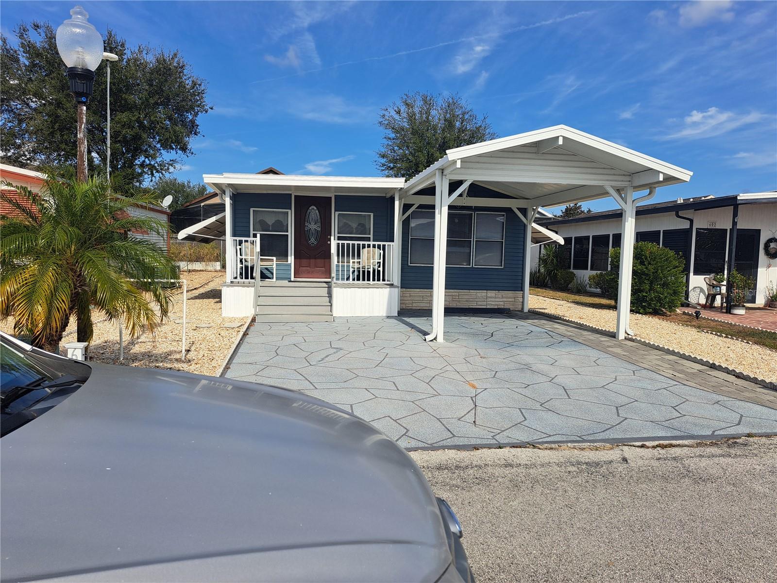 YOU OWN THE LAND! All one level inside, no step up. Hard to find 2 bedroom, 2 full baths (washer in 2nd bath). Laminate flooring throughout. Private paved patio in rear with shed (where gas dryer is). Stone landscaping all around, so not much in way of yard work. Double driveway with carport for 1 car, and open space for another car and a covered front porch. Many activities in clubhouse such as Bingo, cards, dance lessons, holiday dinners, Wednesday grill day with hot dogs & hamburgers, chips, soda, and Ice Cream for a small fee and most times entertainment! AC is about 12 years old, Membrane (rubber) roof was put on in March 2015. Gate is closed 24/7 . Located close to Advent Hospital, doctors, pharmacies, restaurants, shopping center with many major tenant's. Interstate I-4 is 20 minutes away to send you to area beaches and Orlando attractions.