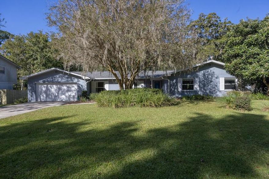 This hard to find four bedroom concrete block home in the highly desirable northwest Gainesville neighborhood of Brywood is only a short two mile commute to the University of Florida and Shands Hospital. The large fenced lot is shaded by beautiful trees with mature landscaping. A full renovation in 2020 included new flooring, updated bathrooms, a gourmet kitchen with new cabinets, black stainless appliances and granite counter tops, as well as new windows and fresh exterior paint. Directly off the foyer is a formal living room and dining room leading you to the gorgeous kitchen and breakfast room with beautiful backyard views. The huge family room with built-in shelving and a wood burning fireplace opens to a screened lanai perfect for enjoying the north central Florida weather. The spacious primary suite with a walk in closet and glass enclosed shower is a relaxing retreat to come home to, and the three secondary bedrooms are uncommonly large with plenty of closet space. To top it all off, a brand new architectural shingle roof was installed last week. Call today to schedule a private tour of this wonderful home!
