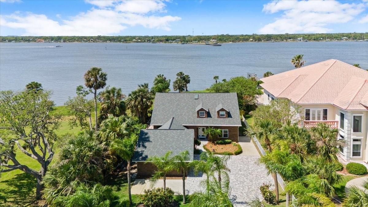 Beautiful remodeled RIVERFRONT POOL HOME offering the very best quality of life the area has to offer! Located directly on the Halifax River within walking distance of direct beach access, this warm and inviting coastal home is bursting with natural light, oversized bedrooms, a massive fenced backyard, and more than enough storage space for any family! Situated high enough to have no flood history with a 2021 roof, brand new paver driveway, 2021 and 2023 AC units, impact windows, hardwood floors throughout most rooms plus gorgeous tile in the remodeled granite kitchen with stainless GE appliances, eat-up island, custom dinette with wraparound bench, plus formal dining. This home has a HUGE first floor primary suite with two walk-in closets, beautiful ensuite bath with walkthrough shower, plus an extra den/office/gym space with views of the river. The first floor also features a music room and a riverfront office that could easily be used as a 4th bedroom.
The 2nd floor has a large landing that would make for an excellent play space or secondary living room, two extra long bedrooms with views of the river, ABSOLUTELY STUNNING remodeled bathroom with dual vanity, walk-in shower, and modern standalone soaking tub. Besides the large closets in each bedroom, there is also a walk-in attic space for all of those extra decoration bins and much more.
On the main level, the western living room has vaulted ceilings and windows on all sides allowing endless natural light to flow in. French doors open to the paver patio and pool deck before leading to the lush and large fenced backyard. This part of the Halifax River is breathtaking and is part of the Intracoastal Waterway so views will continuously include marine life like dolphins and manatees as well as boat traffic of all shapes and sizes throughout the year plus SUNSETS LIKE YOU CANNOT BELIEVE! Don't let this opportunity pass you by, once you live the easy life in a spot like this, you will never look back!