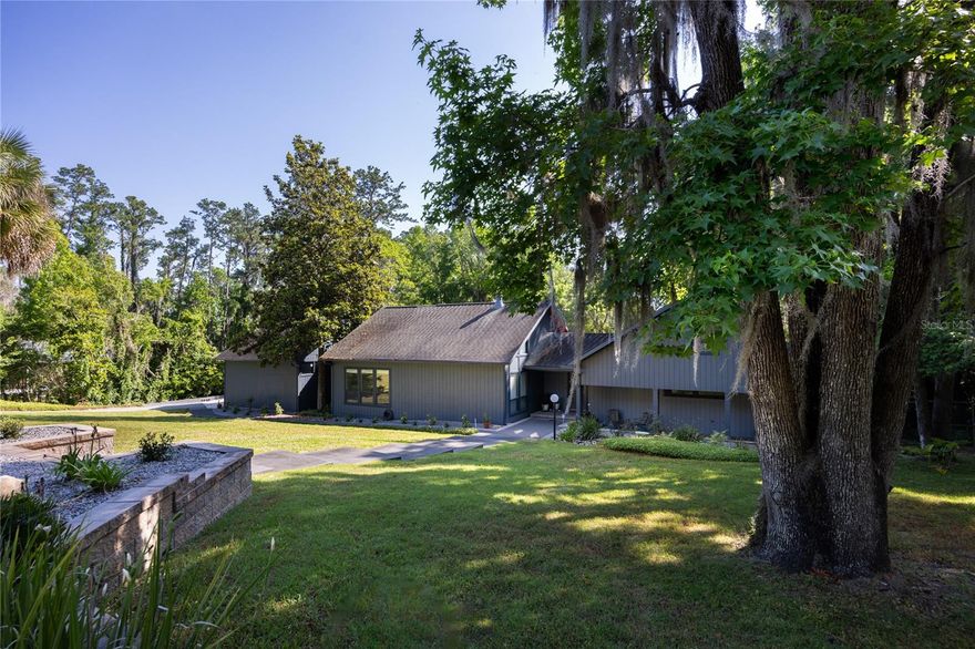 Amazing Scandinavian Modern home that combines minimalist design, sleek lines and yet remains warm and inviting. Built in 1981, this 3 bedroom plus flex space/4th bedroom, 2.5 bathroom home is impeccably maintained. You will love the close proximity to the University of Florida, Shands/UF Health, PK Younge, airport and downtown Gainesville. Yet its location in the neighborhood makes this home a quiet and peaceful retreat on a cul-de-sac street. Walk to nearby Sweetwater Wetlands Park, mountain bike trails and Bivens Arm Nature Park. From the covered front entry, you step into the foyer. The home is divided into living and sleeping wings with an amazing Chef's Kitchen playing center stage. To your left is the Family Room with dramatic high ceilings, beautiful heart pine wood floors, soaring wood burning stove and banks of windows for a ton of natural light. The Family Room is open to the modern Kitchen with breakfast bar, breakfast nook, quartz countertops, stainless steel appliances, induction cooktop and ample storage space. The breakfast nook is perfect for your morning coffee with a wall of floor to ceiling windows overlooking the deck and beautiful backyard. Just off the Kitchen is a half bathroom and a laundry room with washer and dryer, laundry tub and cabinets for extra storage. Also off the Kitchen is a screened breezeway that leads to the deck and the oversized two car, side entry garage. There is a large workshop and a darkroom, plenty of space if you need an ADU or an attached in-law suite The home has central vacuum. Roof is 2009. Two HVAC systems. Two septic systems. Tankless water heater for living spaces and separate water heater for the bedrooms. Step through the Kitchen to a Dining Area. This space is open to the Living Room with high ceilings and built-in bookshelves. There is a circular staircase that leads to a loft space full of natural light with built-in storage, sink and is perfect for an artist or home office. Back at the Foyer, if you turn right and go upstairs you arrive at the Primary Suite. This very large space with high ceilings has an ensuite bathroom that has been updated with wood cabinetry, double sink vanity and granite countertops. There is a separate shower and water closet. This home is absolutely full of storage space and the primary suite has a wall of closets with room for dressers and custom shelving. Downstairs has a flex space with transom windows that is currently used for workout equipment, but could easily be a homework station or in-law suite living area. The first bedroom has a built-in bookshelf, updated lighting and separate entrance to the rear wood deck. There is a Jack and Jill Bathroom that the guest rooms share with a tub/shower and water closet, but each room has its own vanity and sink. No more fighting over mirror time! The second guest bedroom has its own access to the rear deck as well. The large rear deck spans the back of the home and has updated railings and was expanded by the current owners. The home sits on an oversized lot of .75 acres and has a fenced, rear yard. There are vegetable beds and a low maintenance garden. Colclough Hills is near the new South Main Street Aldi, Depot Park, First Magnitude Brewery and Heartwood Soundstage Entertainment Area. No HOA.