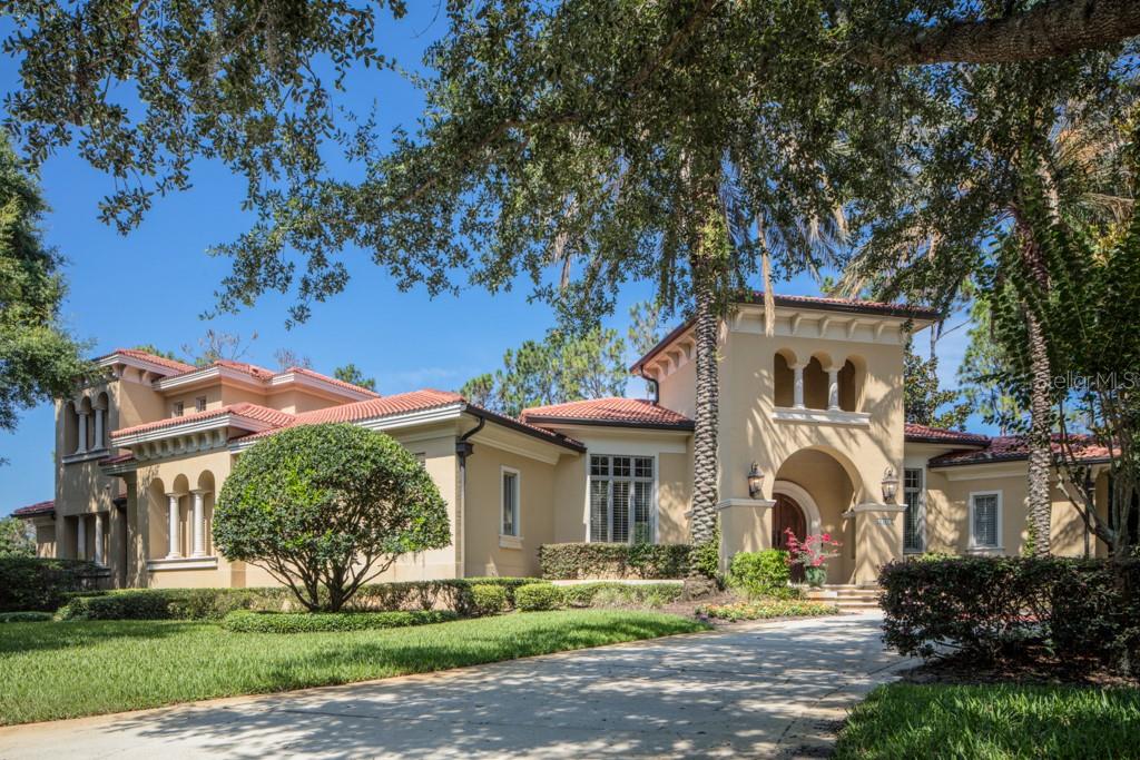 Within the gates of Isleworth West, this elegant estate is nestled on a large corner home site and spans more than 4,800 square feet of living space. Beautiful custom doors reveal a lovely formal living room with an expansive bay window that frames the sparkling open-air pool, spa and lush landscaping. The formal dining room and butler's pantry lead further to the home's central gathering area, which includes the island kitchen with custom cabinetry, professional appliances and granite countertops, as well as a breakfast nook and spacious family room with built-in media center and sliding glass doors to the pool area. Featuring a light-filled sunroom that opens to the lanai, the spacious master suite offers a walk-in closet and large bath with dual vanities, a walk-in shower and clawfoot tub. The nearby home office also opens to the sunroom and feature beautiful wooden built-ins and a coffered ceiling. Further highlights of the interior include three additional bedroom suites on the upper level and a tree-car garage. Designed for entertaining, the outdoor living area boasts a summer kitchen and fireplace complimenting the private, custom swimming pool and spa.