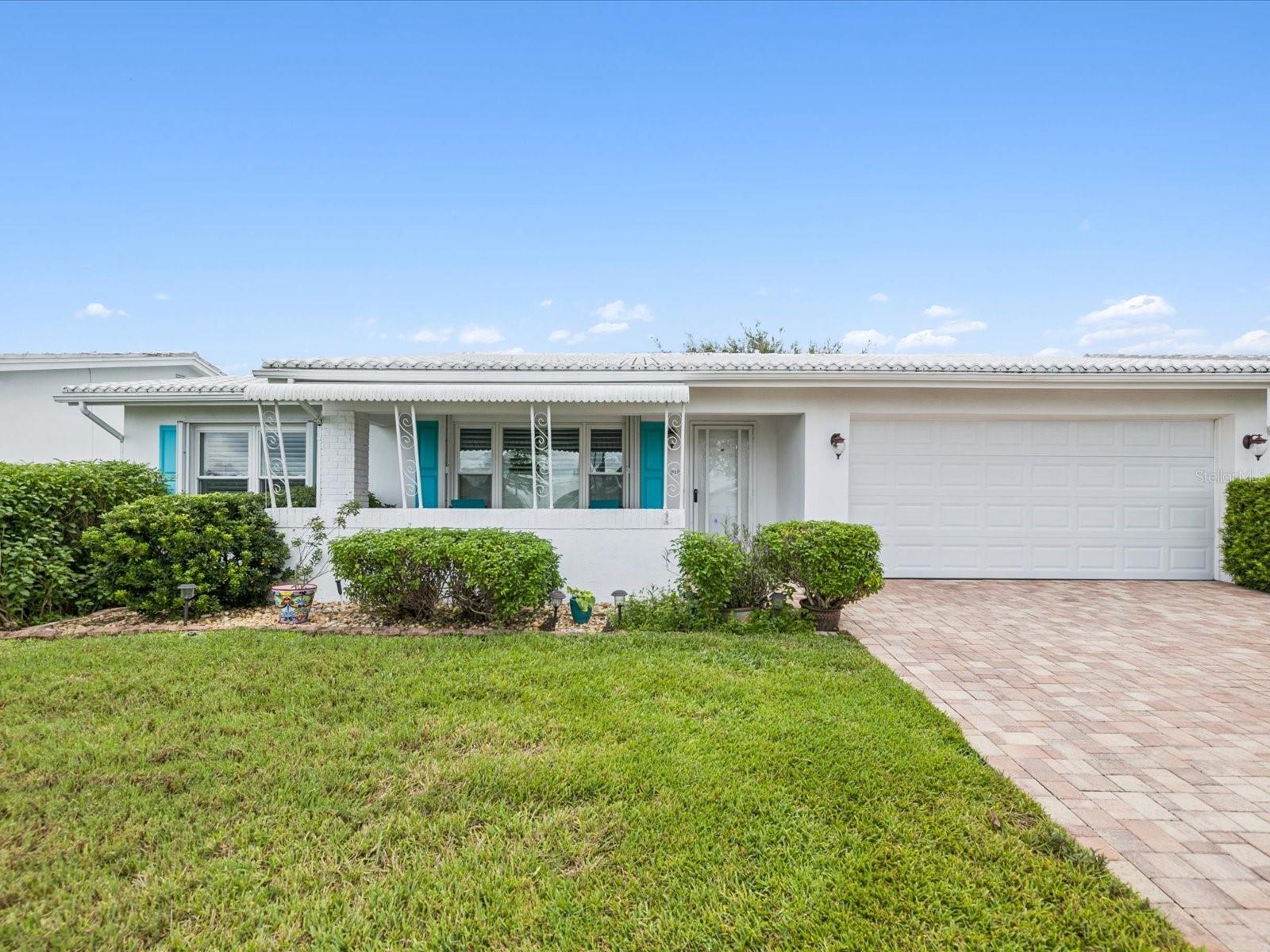 This beautifully maintained home offers both style and peace of mind, starting with a paver driveway and front patio, a new hurricane-rated garage door (2021), and accordion hurricane shutters with locks and keys for all windows. Inside, the layout features engineered hardwood floors throughout the home, plantation shutters on every window, and a welcoming living room that flows into a kitchen with quartz counters, soft-close drawers, composite sink, pantry, and white appliances (2017). Multiple dining options include a formal space with chandelier and a cozy informal nook with built-in cabinetry. The enclosed flex space with 5 windows and closet provides endless versatility. The spacious primary suite boasts a walk-in closet with mirrored doors and an ensuite bath with step-in tiled shower, quartz vanity, and abundant storage. Additional highlights include a 2nd bedroom with custom built-ins, a 2nd bath with pocket door and quartz finishes, and a large family room filled with natural light. Practical upgrades ensure lasting value, including an upgraded electrical panel (2015), whole-home surge protection (2017), HVAC (2017), water heater (2022), water softener (2022), and a tile roof (2005, inspected and certified in 2024 with 10 years of life remaining). All windows were replaced in 2010 with tilt-in easy-clean design, and the garage offers extensive cabinetry, built-in shelving, and pull-down attic stairs with partial flooring. With paver walkways, gutters, an open backyard with grass, and no homes across the street. This home blends thoughtful upgrades, functional living, and a prime location into one perfect package.