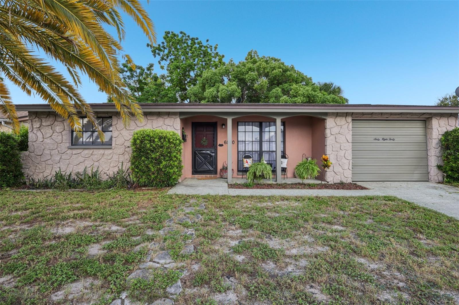 This beautiful 2-bedroom, 1.5-bathroom home is exceptionally clean, well-loved and waiting for its new owner. Walk in the front door and it feels like home. The Vinyl wood plank flooring flows through out this home, rich in color and easy to maintain. The open floor plan is desirable as it gives many options for larger furniture, and flexibility when designing your personal living space. The centrally located gally style kitchen offers plenty of storage with updated cabinetry, counter tops, tiled back splash, designer kitchen sink, range and hood. There is an inside laundry room, that has additional space for storage. Bedrooms 1 and 2 have plenty of room for large beds, furniture and room to spare. The full bathroom separates the two bedrooms, has a single vanity, and a bathtub/shower combo. The garage has been converted into a inside bonus room, that can double as a home office, play area or an additional space for guests. Open the garage door from the outside and you have storage for your lawn mower, yard tools and more. Additional concrete was poured to more than double the width of the driveway for ample parking, with an additional walkway into the fenced in back yard. There is a large covered and screened Florida room out back, plus an additional concrete patio to further enjoy the semi-private back yard. The location is fantastic, extremely close to dining, entertainment, shopping, medical, colleges, area beaches, beautiful downtown New Port Richey and even an A rated private school. This home is high and dry located in flood zone X. Call today for your private tour, and if you have any questions – Just ask.