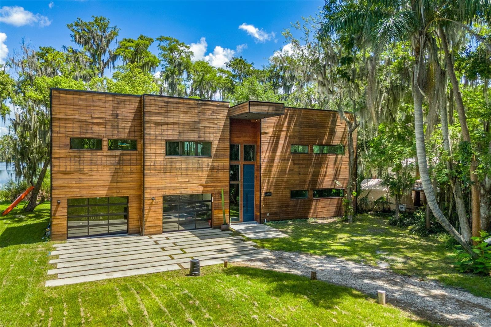 Rent to Own is an option! Video Link: https://www.instagram.com/reel/C9LgmwvsLfM/?igsh=MTFxdmhvMTdqbWZ2dg== Drive down the long private road surrounded by indigenous plants and trees, taking you out of the city and to your own very secluded lakefront oasis. As you pull into the driveway you will see the amazing newly built modern contemporary lake front home. The beautiful Brazilian hardwood sided house will impress everyone that comes to visit you. The first floor boasts two bedrooms and two baths A gym and laundry room. The contemporary design comes through in the floating staircase and the polished cement floors. Climb the stairs to enter the open concept main floor including the large primary suite. The large windows giving you the lake views that you have been looking for. The second floor oversized deck with an Argentinian fireplace/BBQ, will be the place to entertain your guests. Schedule an appointment to see this amazing, unique property!