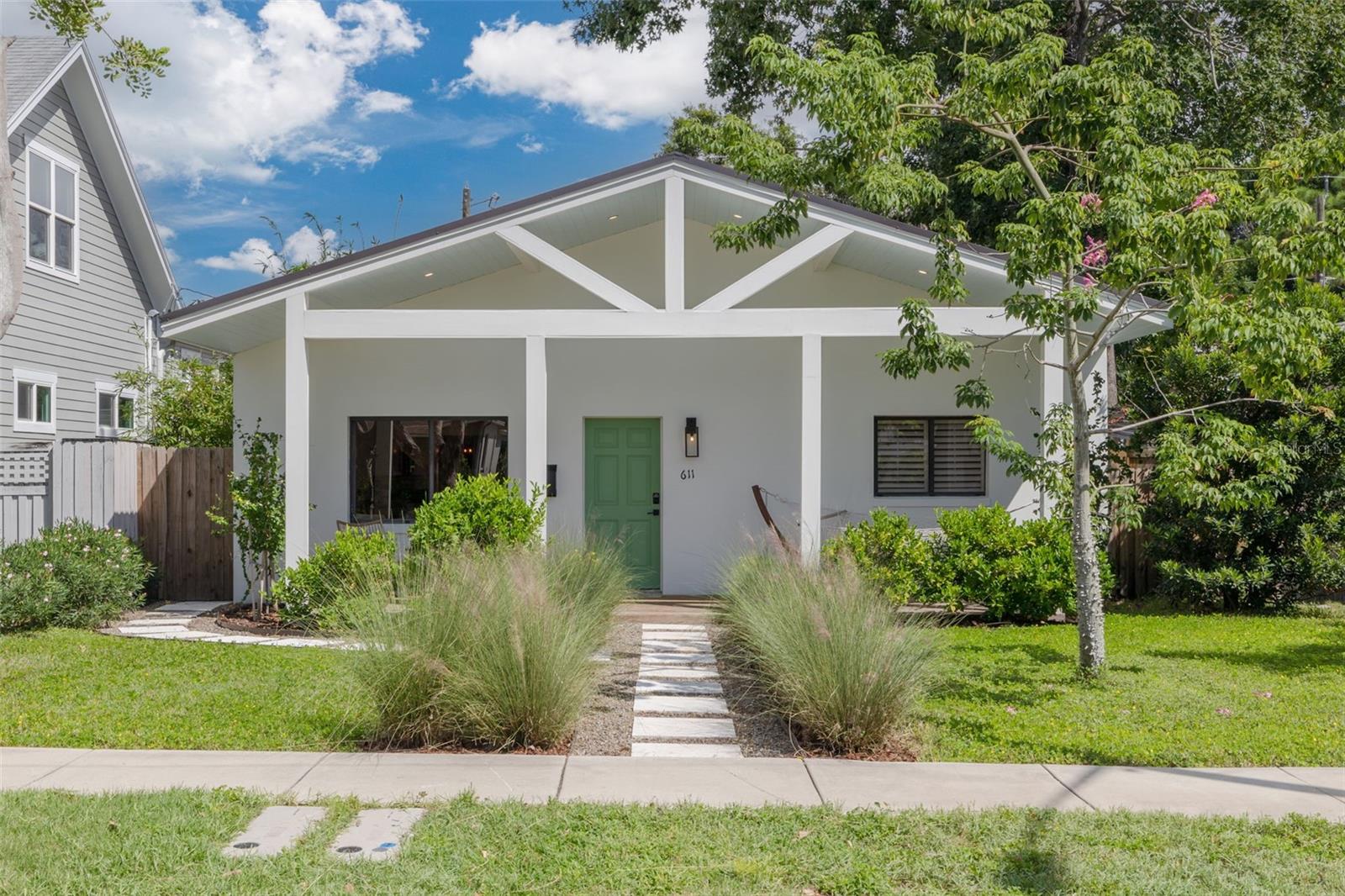 This modern bungalow sits high and dry in Flood Zone X, right in the sought-after 5 Points neighborhood of Downtown St. Pete. With 4 bedrooms, 2 bathrooms, approximately 1,611 square feet, and a detached two-car garage, it combines style, function, and location. Step onto the spacious front porch, where a single hammock stretches across the far end, perfect for afternoon lounging. Natural wood decking, leafy planters, and a mint-green door give the entry a bright, inviting feel that’s equal parts stylish and relaxed. Inside, you’ll find updated flooring and an open-concept kitchen featuring modern appliances, sleek countertops, and stylish cabinetry. The guest bedrooms are positioned toward the front of the home with convenient access to the guest bath. Scandinavian design principles shine throughout - minimalism, natural light, and functional simplicity. The primary suite overlooks the backyard oasis and offers a walk-in closet plus a stunning monochromatic walk-in shower with dual shower heads and a double vanity. An indoor laundry closet sits near the back of the home between the primary and fourth bedrooms. Currently used as an office, the fourth bedroom features French doors opening onto the back patio. The fully fenced yard and detached garage with alley access complete the outdoor living space. Perfectly located, you’re just seconds from 4th St. N and MLK, minutes from I-275 and Downtown St. Pete, and close to favorite local spots like Trader Joe’s, Publix, Whole Foods, Fresh Market, El Cap, Red Mesa, Crescent Lake, Crisp Park/Boat Ramp, Coffee Pot, and so many others. This move-in-ready home truly has it all! Call today and come see for yourself.