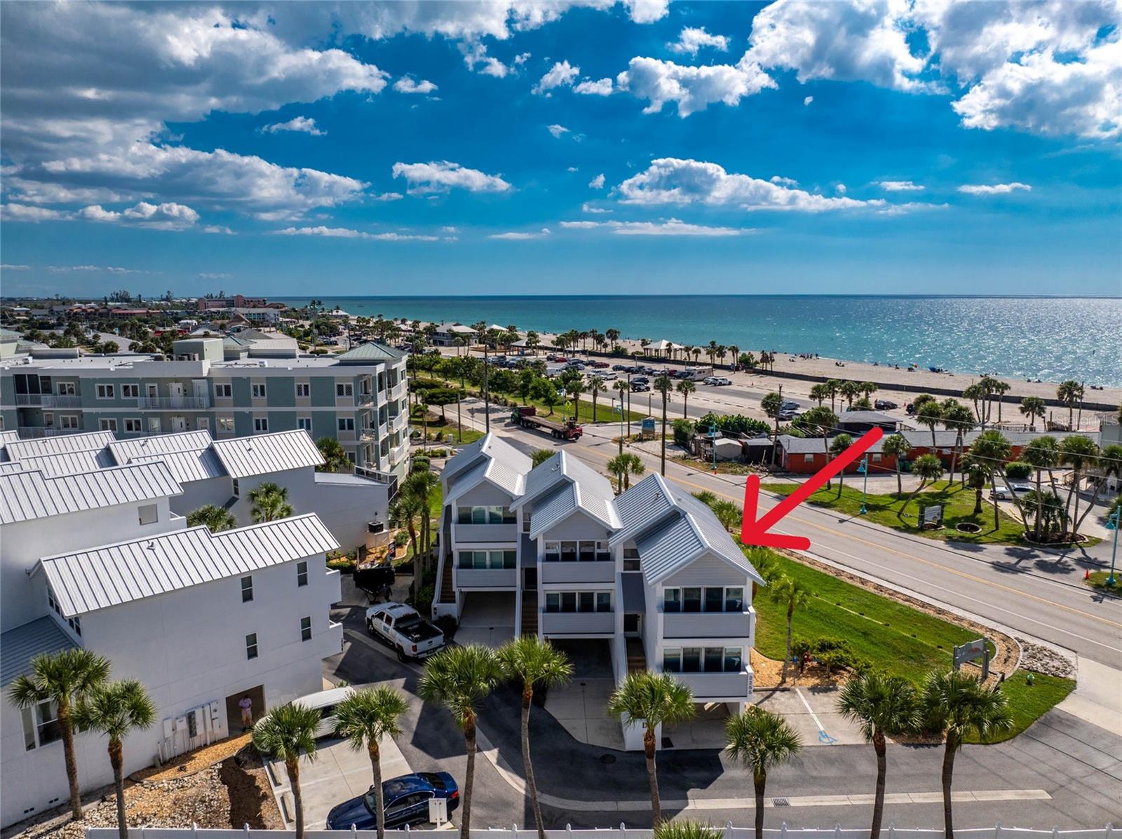 Welcome to your sunlit coastal retreat at Live Oak Landings Condominiums on Manasota Key. This beautifully bright and open 2Bed/2Bath (+ Loft) townhome is offered fully furnished and offers partial views of the Gulf. The location doesn't get much better than this! Nestled just a stone's throw from all island restaurants and shopping and just across the street from Englewood beach, this well-maintained townhome offers the ideal Florida lifestyle. Dock your boat in the common slips on Lemon Bay, take a refreshing swim in the heated pool, or stroll across the street to the beach. The unit features all new luxury vinyl plank flooring and carpet throughout, and all sliding glass doors are storm/impact rated. Enjoy morning coffee or breathtaking sunsets from the open balcony. Vaulted ceilings adorn the dining and living areas. The top floor primary suite offers a beautifully updated bathroom, and the downstairs bedroom suite includes an updated shower. Both bedrooms include balconettes with screened sliders, perfect for letting the Gulf breezes flow through the unit. The top floor loft/den provides a scenic Gulf view and is a perfect flex space for overnight guests, or for an office/den space. Unit offers a 1-car covered carport area, located just in front of the private 1+ car garage. The outdoor shower is ideal for rinsing off after coming in from the beach. Live Oak Landings is a 23-unit, bay front community featuring a heated pool with paver patio, privately owned & common slips, and guest parking for its residents. This is the perfect spot for coastal living.