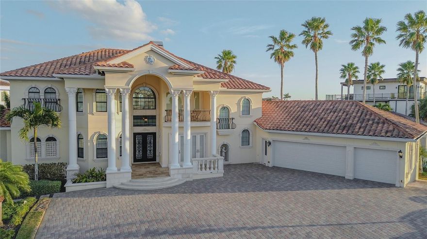 One of the lowest flood policies on the barrier islands — assumable at just under $1800 annually.  Rare Belleair Beach Opportunity | Elevated Construction & Dual Water Views.  Perfectly positioned across from the Gulf in coveted Belleair Beach, this elevated 5-bedroom coastal residence offers construction above the flood plain in the AE zone. Designed for true coastal resilience, the home features hurricane-impact windows and doors, a wind-mitigation-qualified tile roof, reinforced garage door, and a whole-house Generac gas generator that automatically powers essential systems including air conditioning, appliances, and lighting. The property performed exactly as designed during recent storms, offering both security and peace of mind. Inside, imported Italian marble flooring, custom ironwork, and hand-painted tile murals showcase exceptional craftsmanship, while a dramatic crystal chandelier anchors the grand living room. The spacious floor plan includes five bedrooms plus a beautifully appointed executive office. Wraparound balconies span the entire second level, capturing rare dual-water views of the Gulf of Mexico to the west and the Intracoastal Waterway to the east from every upstairs room. The private pool and spa create a resort-style setting enhanced by smart home technology controlling security, lighting, irrigation, and pool systems from anywhere. Located minutes from Clearwater Beach, the waterfront charm of Dunedin, and within easy reach of Tampa International Airport and Downtown Tampa. Competitively priced at $3.2M, this Belleair Beach residence delivers luxury, resilience, and exceptional coastal living.