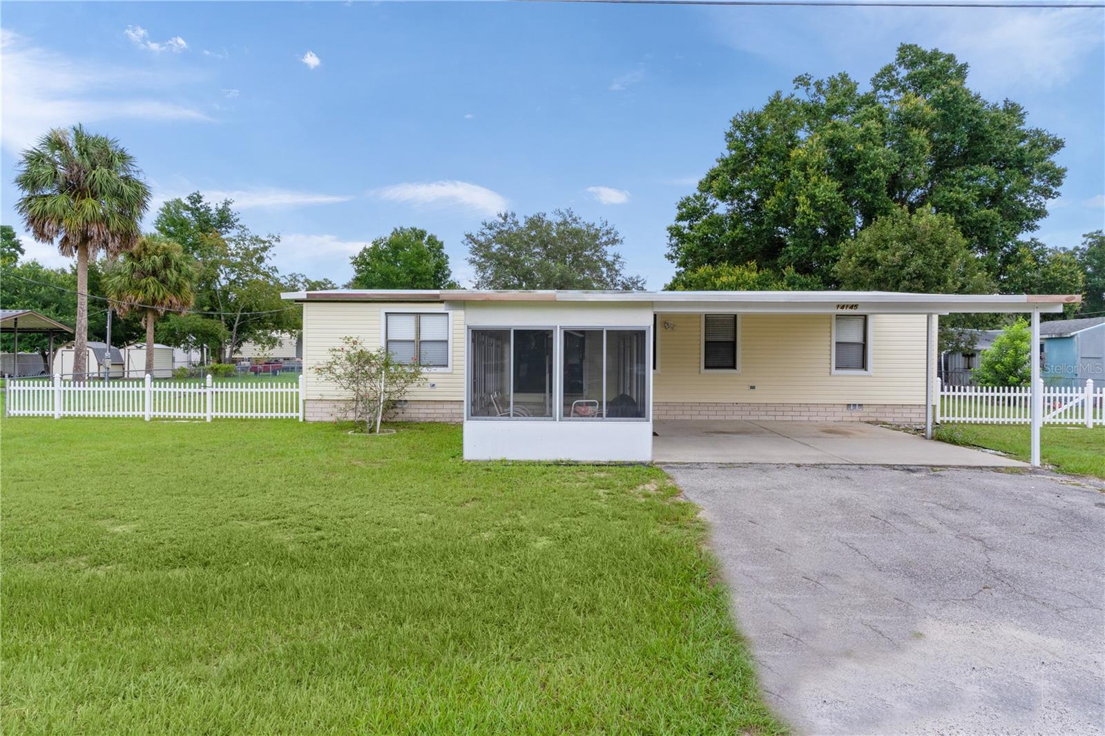 Welcome to this spacious 3-bedroom, 2-bathroom home with 1,352 sq ft, located in the desirable Little Lake Weir neighborhood. This home sits on a .30-acre FENCED lot and includes a SHED and a carport suitable for 2 cars. ROOF 2022. An ENCLOSED LANAI at the front of the home offers additional entertaining space. This TURN-KEY FURNISHED property is perfect for seasonal use, rentals, or simply moving in with just your toothbrush. The Primary Bedroom is generously sized and features a walk-in closet and an ensuite bathroom. Both Guest bedrooms also have large walk-in closets, with a guest bathroom conveniently located nearby. The Kitchen is equipped with ample cabinet space, a New Refrigerator, and Laminate flooring that leads into the dining room. A Washer and New Dryer are included for your convenience. The back SCREENED PATIO serves as a perfect retreat. This home is conveniently located near Little Lake Weir, Lady Lake, and The Villages, with easy access to shopping, restaurants, medical facilities, and entertainment options.