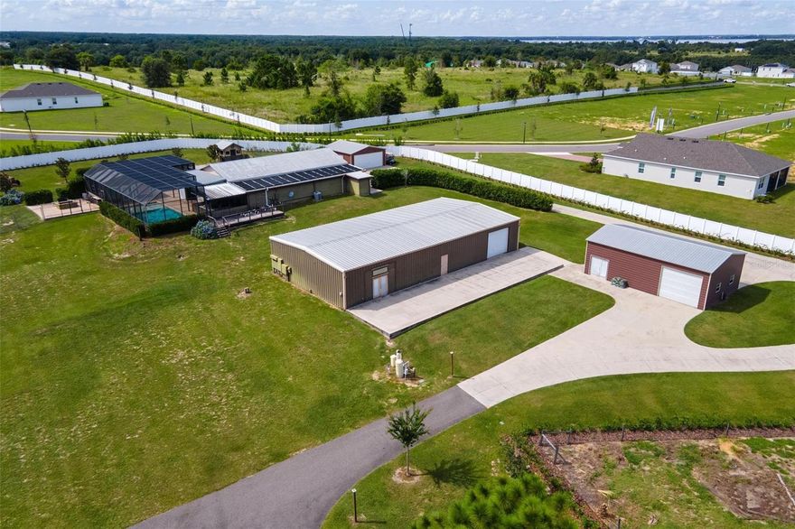 One-of-a-Kind Barndominium Estate on 5.6 Acres. Discover one of Lake County’s most unique properties, offering unmatched versatility and privacy on 5.6 fully fenced acres with 2 entry gates, main gate is solar powered. This exceptional estate features two barndominiums, multiple metal buildings, a  pool, and a wealth of outdoor living spaces. The main barndominium provides 1,957 sq ft of stylish living space with 2 bedrooms, a spacious walk-in closet, an open kitchen and living area, and a large full bath with a beautifully tiled walk-in shower. Attached is a 1,243 sq ft storage/workshop with an overhead door and an expansive 80' x 20' concrete patio perfect for entertaining or hobbies. The second barndominium offers over 2,800 sq ft of open living space, complete with a full kitchen, bar area with kegerator, stainless steel BBQ station, outdoor shower, and half bath. Inside, enjoy 900 sq ft of heated and cooled space that includes a private bedroom with walk-in closet, a full tiled bath with walk-in shower, and a living room with laundry closet. Step outside to a 50' x 28' screened-in solar heated pool with a 20' x 16' pool house, featuring a mini-split system, built-in bar, and kegerator ideal for year-round entertaining. Additional highlights include a 23' x 24' concrete firepit, a 30' x 10' wood deck patio, a 24' x 24' detached two-car garage, and a 40' x 24' metal building with overhead door for even more storage or workspace. 650 amp service all on one meter and 500 gallon propane tank. This property offers endless possibilities expand the main residence, create a family compound, or enjoy it as a private retreat. All of this is centrally located in Central Florida, with easy access to Leesburg (The Lakefront City), Tavares (The Seaplane City), and the Florida Turnpike.