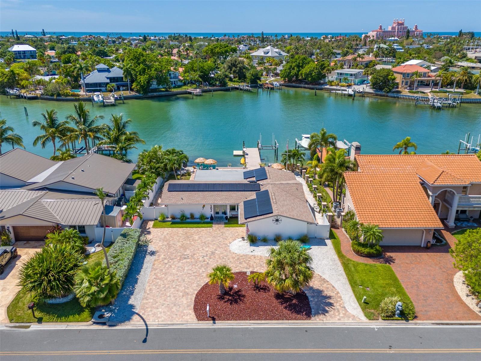 ENJOY BEACH LIVING AT ITS BEST IN VINA DEL MAR, one of St. Pete Beach’s most sought-after neighborhoods! This 3-bedroom, 2-bath, waterfront, pool home has been beautifully remodeled and is ready for you to move in. West-facing water views provide spectacular sunsets. Situated in a private cove of the Boca Ciega Bay, there is minimal boat traffic providing protection to your seawall while still allowing quick and easy access to the Intracoastal and Gulf of Mexico with no fixed bridges. A dock with a 9k lb boat lift, electricity, additional floating dock for easy paddleboard and kayak launching and fish cleaning area is perfect for all your boating and fishing needs. The minute you step in the front door, you will fall in love with the bright, open views. The finished sunroom not only offers additional living area, but also features a wall of windows, with custom blinds, bringing the sunny outdoors inside. Tasteful updates include beautiful white porcelain tile flooring, remodeled kitchen with white shaker cabinets, quartz countertops and stainless-steel appliances, updated bathrooms, new crown molding, baseboards, interior doors, and hurricane-rated windows throughout. Newly added door off the kitchen area allows easy access to the outdoor kitchen and outdoor dining space with an electric retractable sunshade awning for added comfort. The master bedroom features an ensuite bathroom, walk-in closet with custom closet system and private door that leads to the backyard. The split floor plan provides comfort and privacy with two additional bedrooms and a bathroom located on the opposite side of the house. The spacious second bedroom is plenty big enough for a king-size bed, has an extra-large closet and custom room-darkening blinds. The third bedroom includes a queen-size murphy bed making it perfect for a home office/bedroom, featuring custom room-darkening blinds and a private door accessing the backyard. The fenced backyard is your own private waterfront oasis with a sparkling pool with attached hot tub with relaxing waterfall feature, outdoor kitchen with built-in gas grill and refrigerator, large pool deck with all new pavers, outdoor speakers, ambient lighting and Florida-friendly landscaping. It’s the perfect setting for entertaining, lounging in the sun and enjoying stunning sunsets. The salt water pool has been refinished and a new pool pump and filter were just installed. The garage offers a laundry area with a newer washer and dryer, abundant storage space and parking for one car or golf cart. Sellers installed a 5-ton A/C unit, which would be sufficient for future expansions to the home. Additional features include solar panels on roof for lower electrical bills, Generac 22KW whole-house generator, under-sink R/O water system and Insteon SmartHome technology. The circular driveway, with new pavers, allows for easy in and out. Nearby is Vina Del Mar’s park with Tennis, Pickle Ball, Basketball, playground, fenced dog parks, pavilion, exercise area and benches to enjoy the neighborhood and visit with friends. Vina Del Mar is located in quaint Pass-a-Grille with the beautiful Gulf beaches, restaurants and shopping just a short walk, bike or golf cart ride away, as well as being perfectly located with easy and quick access to vibrant downtown St. Petersburg, the Interstate and airports. Vina Del Mar is the true sense of community with holiday golf cart parades and community gatherings.