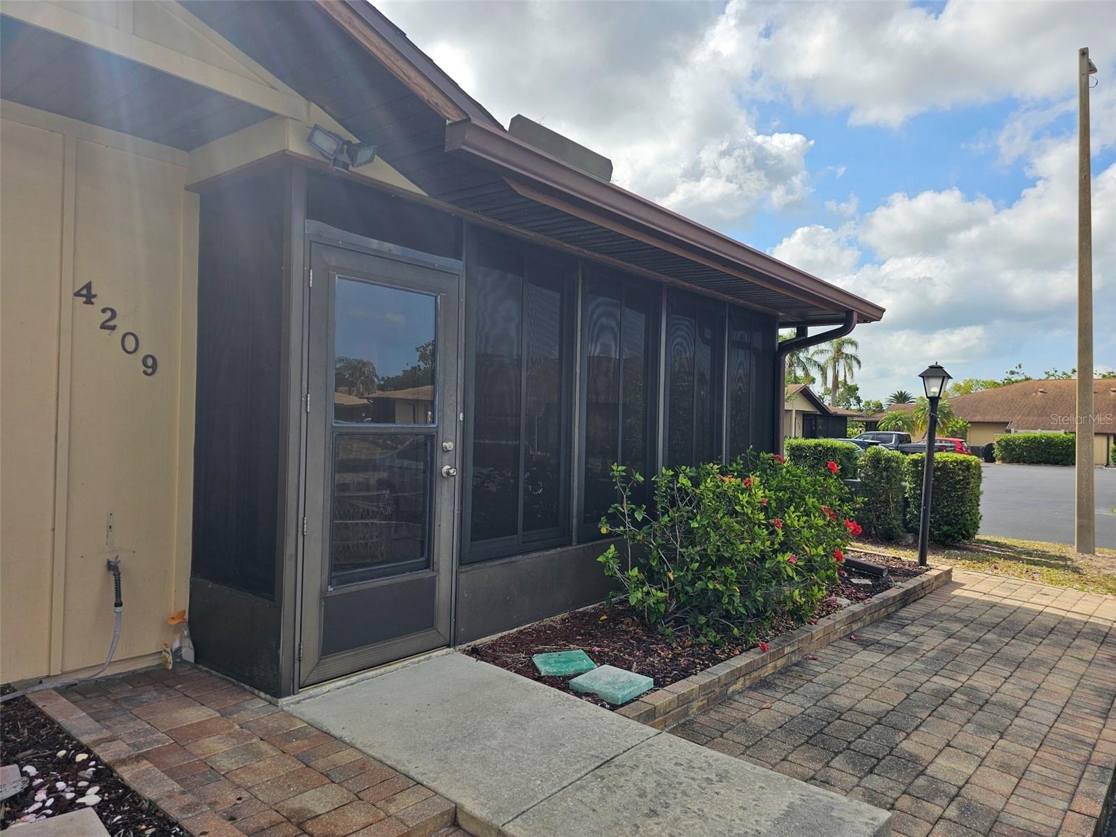 Welcome to this inviting ground-level villa in a desirable 55+ community, offering both comfort and convenience. The open great room design features tile flooring throughout with soft carpet in both bedrooms, creating a warm and functional living space. The kitchen is designed for everyday ease, with a dining table, breakfast bar, and granite countertops, along with a large laundry and storage room tucked just off the kitchen. The main bedroom offers a king-sized bed, walk-in closet and a private bath with a walk-in shower. The guest bedroom doubles as a flexible den or bedroom, complete with a Murphy bed and French doors leading to the front patio. This enclosed patio, finished with tile flooring and glass panels, makes for the perfect spot to relax year-round. Community amenities include a clubhouse and heated swimming pool, while just outside the entrance to the community, you’ll find a charming plaza with restaurants, pubs, boutiques, and more. And when you’re ready for a day by the water, our beautiful Gulf beaches are only a short drive away. The listed price reflects a six-month lease, with the option to enjoy a lower monthly rate on a one-year lease.