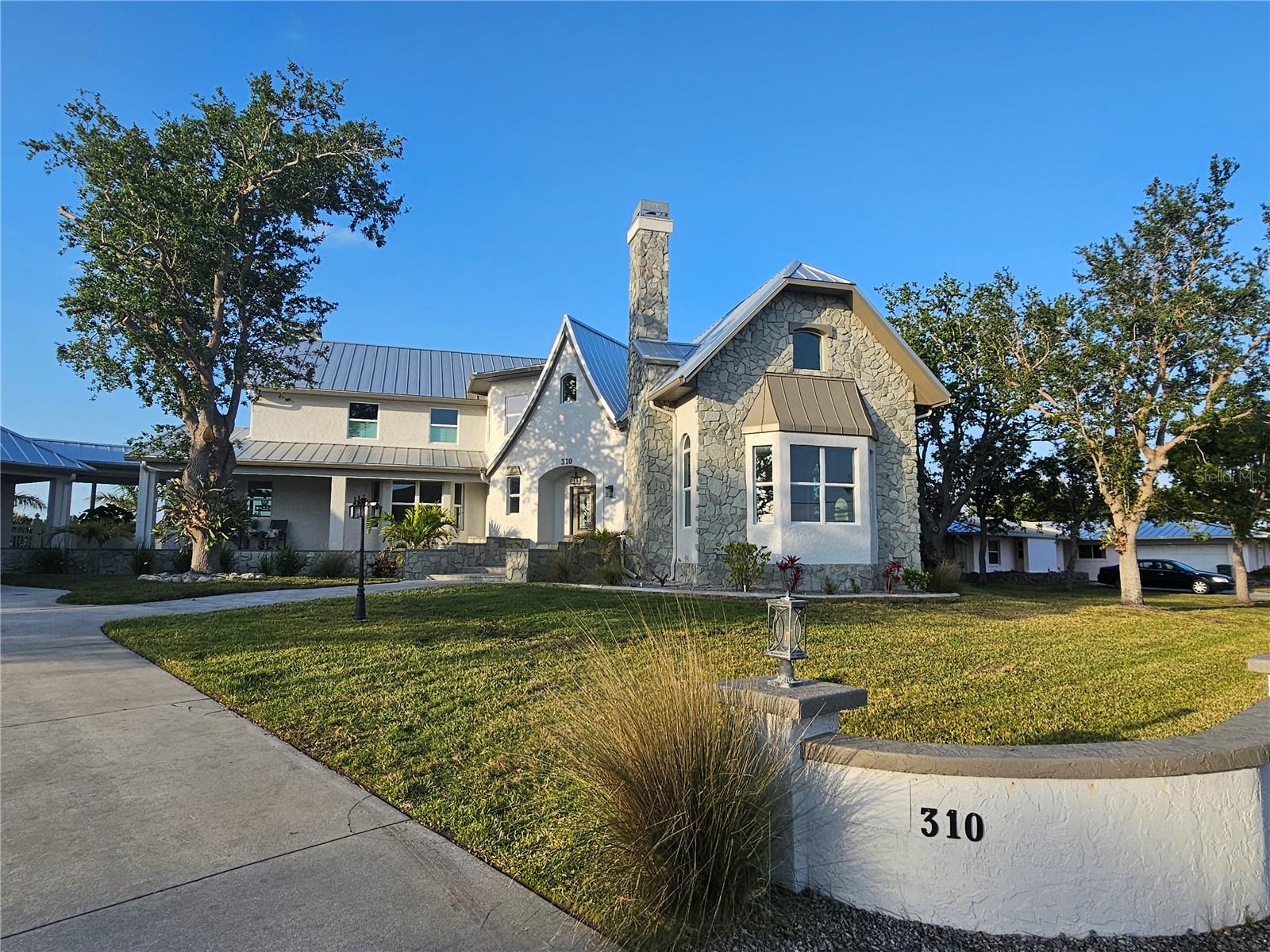 RARE FIND! COMPLETELY RENOVATED STUNNING WATERFRONT MASTERPIECE! This custom-built 5 bedroom, 3 full, 3 half bath, 5,324 sf home has been meticulously updated to blend modern luxury with ultimate peace of mind. Situated on a double lot with wide turning basin views, 16,000 lb. covered boat lift, composite dock with water and electric and offers 5 MINUTE SAILBOAT ACCESS TO CHARLOTTE HARBOR LEADING TO THE GULF! From the moment you arrive, the impeccable curb appeal with unique exterior stone chimney and curved masonry walls sets the tone for a home that exudes quality and sophistication. Built for both comfort and maximum storm protection, this home features a 12 ft. elevation, hurricane-impact windows and doors, a whole-home generator supporting everything from the pool to the multiple AC units, new standing seam galvanized steel roof plus new electric panels and upgraded plumbing fixtures. Moving through the breezeway, you’ll find a very special feature of this home. The garage is equivalent to a 4-car garage with 2 bays built-in with additional living space offering a kitchenette, full-size refrigerator, commercial ice maker, sink and microwave-a perfect prep area for outings or late-night poker games plus there is a convenient attached pool bath and outdoor shower. Throughout the home, you’ll find refinished wood floors, elegant new light fixtures, and sleek porcelain tile. The completely new kitchen is a chef’s dream, featuring a gas range, KitchenAid stainless appliances, a reverse osmosis system, and counter seating. A custom kitchen hood blends style and function, making this space as beautiful as it is practical. A pass-through window leads to a versatile entertaining room with new built-in cabinetry—perfect for hosting. Off the kitchen, the family room with a gas fireplace offers the perfect spot to enjoy lanai and water views. Step outside to a brand-new pool and spa, where the picture frame screen showcases breathtaking water views. The pool deck and lanai space feature stunning travertine and the outdoor kitchen completes this paradise. The first floor also features three guest bedrooms, two of which are en-suite, plus a convenient indoor laundry room and an additional half bath. Upstairs, the primary suite is a true sanctuary. This oversized retreat offers plenty of space for a private sitting area, creating a luxurious escape. The spacious walk-in closet features two pocket door entry points and built-in organization, while the ensuite bath enhances the retreat-like feel. Just outside, the private balcony provides an uncompromising waterway view. Down the hall, a convenient kitchenette, additional half bath, extra bedroom, and flex space offer versatility to fit your needs. Perfectly manicured lawns are maintained by a new irrigation system sourced from the property’s well, with each garden bed also irrigated for effortless upkeep. This home is WIFI and phone manageable, from appliances to irrigation to the pool and spa, to name a few. Located close to Port Charlotte Beach Park, Sunseeker Resort, and downtown historic Punta Gorda, you'll enjoy easy access to fine dining, shopping, beautiful parks, award-winning fishing and boating, community events, and entertainment. Plus, you're just a short drive from Gulf Coast beaches. Don’t miss the video walk-thru attached to the listing!