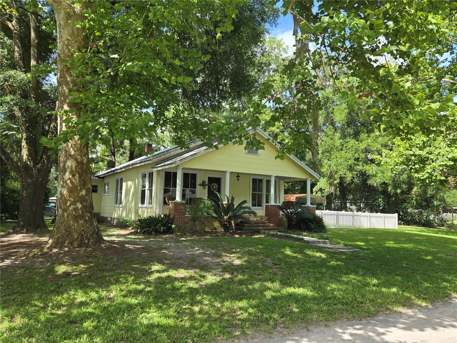 This is a vintage 1924 Craftsman styled 3 bedroom, two full-bath home, built to last with solid heart-pine wood and well cared-for throughout the last century. Situated in a quiet part of High Springs, just six short blocks to the town's center, which has restaurants, shops, a library, pet & feed store, a post office, and our city hall. The house features the classic Craftsman front porch with a real brick base, brick pillars---all in excellent condition; 10 foot ceilings throughout most of the house; bright and roomy kitchen; two back egresses. A large 12x20 living room was added in 1995 in the rear of the house along with a screened room for enjoying your morning coffee while listening to the sounds of chirping birds and seeing hummingbirds feeding. There are also wooded trails just two blocks to the east on the old rail-way lands for nature walks. Exterior amenities include a fish pond with a water fall, an 8x10 wood shed with electricity and an opening for an AC, enclosed fenced area for dogs and a 14,000 square foot lot, with lovely mature trees to add character.