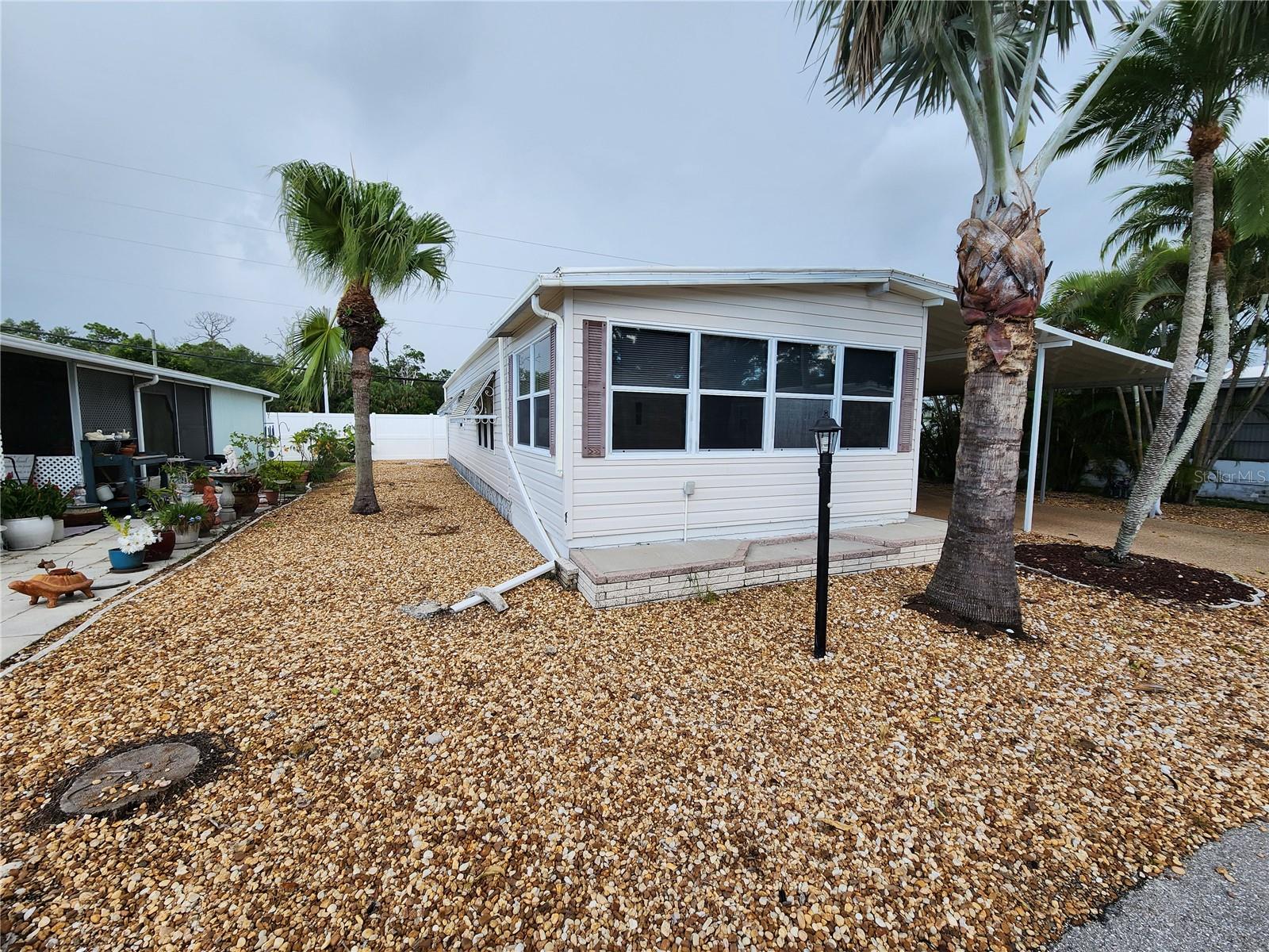 Welcome to #288 Palm Lake Estates, a charming retreat in a vibrant 55+ active community where comfort meets convenience. This beautifully updated home offers peace of mind with all new water lines, a new porch A/C unit, a fresh vapor barrier, and a rebuilt carport. The main house A/C was replaced in 2021, the roof and dishwasher were updated in 2019, and the electrical panel was upgraded in 2025. Enjoy new subflooring and stylish new floors, also completed in 2025, along with a fresh coat of paint that gives the space a bright, modern feel. A 2019 water heater ensures reliable hot water for years to come.
Live worry-free with low-maintenance fees of just $225 per month—covering water, sewer, trash, cable, internet, access to the community pool, and on-site management—all with no lot rent. Perfectly located close to shopping, dining, the airport, and stunning Gulf Coast beaches, this home is an ideal choice for full-time residents or snowbirds seeking a sunny seasonal escape. Let this inviting haven be your slice of Florida paradise.