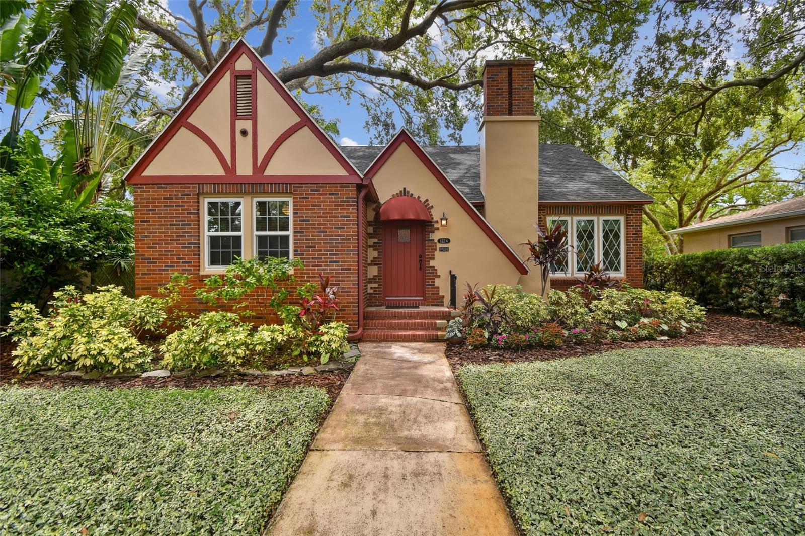 Welcome to this storybook Tudor bungalow nestled in the highly desirable Euclid neighborhood of St. Petersburg—just minutes from vibrant Downtown St. Pete, picturesque Crescent Lake, local shops, popular restaurants, beer gardens, and easy interstate access. Situated among winding brick streets, towering oak canopies, and a beautiful mix of historic charm and tasteful new construction, this home blends timeless character with modern convenience. This 3-bedroom, 3-bath residence greets you with a spacious living room featuring a cozy fireplace, cove moulding, and gleaming oak hardwood floors that flow seamlessly into a formal dining room—perfect for dinner parties and gatherings. The updated kitchen boasts solid wood cabinetry, a brand-new range, and thoughtful finishes, making it both stylish and functional.Just off the dining room, a sun-kissed Florida room offers the ideal retreat for morning coffee, reading, or relaxing, and it opens up to a massive screened and covered outdoor living room. With cathedral ceilings, a gas fireplace, and a fully-equipped outdoor kitchen, this incredible space invites year-round entertaining in your lush, tropically landscaped backyard. The entire second floor is dedicated to the primary suite—a bright and peaceful sanctuary complete with a private bath and plenty of room to unwind and recharge.The home also features impact-rated windows throughout, a tankless hot water heater for energy efficiency, updated plumbing and electrical systems for peace of mind, and a detached two-car garage with a full bath—perfect for an artist studio, workshop, or even a future guest suite. Best of all, the property is located outside of a flood zone and has never experienced any storm damage, offering an added layer of security and confidence. This charming and thoughtfully updated home truly offers the best of indoor-outdoor Florida living in one of St. Pete’s most iconic neighborhoods. Don’t miss your opportunity to own a piece of Euclid's historic magic.