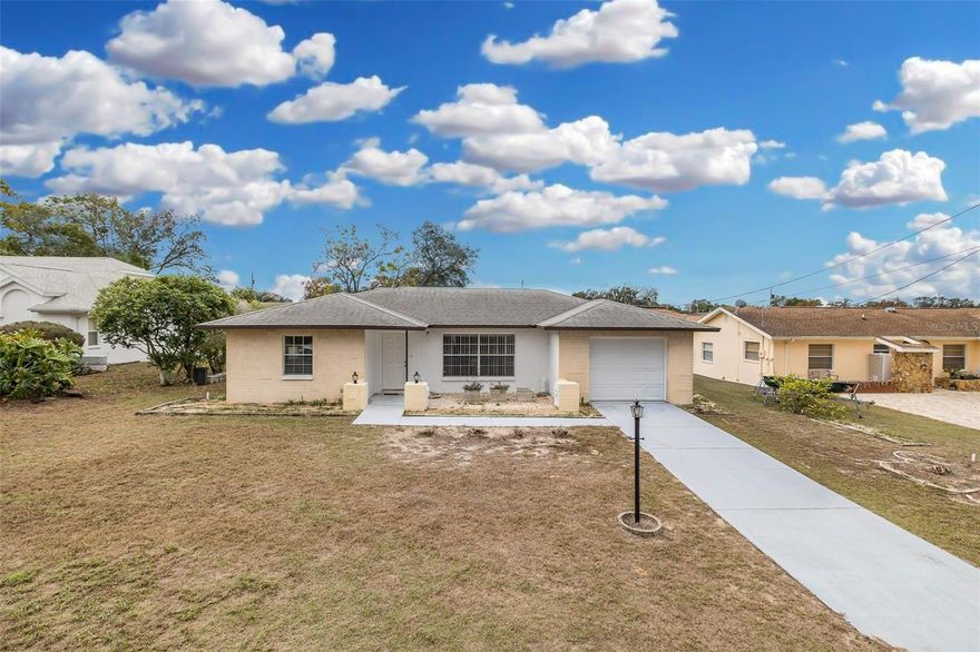 This charming 2-bedroom, 2-bath, pool home with a one-car garage offers comfort, character, and a truly special outdoor retreat. Enter through the front door into the living room which also features a flexible space ideal for a home office or sitting area, highlighted by a large window overlooking the front yard.
The kitchen is spacious and functional with wood cabinetry, ample counter space, a large wall pantry, and plenty of storage. The adjacent eat-in dining area features classic parquet wood flooring, while the kitchen itself is finished with tile floors.
Step down into the Florida room, where a cozy wood-burning stove creates a warm and inviting space for relaxing or entertaining year-round. The primary bedroom is located at the back of the home and includes a large walk-in closet and a private en suite bath with tile flooring and a step-in shower with glass doors. The second bedroom, located at the front of the home, offers a closet and easy access to the full hall bathroom, which features a tub/shower combination, tile floors, and a wood vanity. A linen closet in the hallway provides additional storage.
Outside, surrounded by pavers, the screened-in swimming pool is a true highlight, complete with a built-in seat and steps for easy entry  —perfect for enjoying Florida living. The yard feels like a peaceful garden oasis with multiple garden areas, raised beds, pavers, fruit trees, and lush plantings. Listen to the birds and enjoy the serenity this outdoor space provides.
The one-car garage includes shelving, storage cabinets, a utility sink,  washer and dryer, offering excellent functionality and organization. Remediated ground settlement with all documents, fully insurable and financeable. NO HOA. Roof 2010. HVAC 2000. Come see this gem in person!