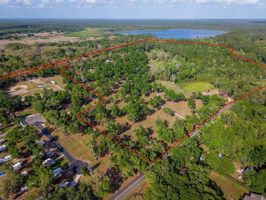 A RARE LEGACY PROPERTY | 62.02 ACRES LAKEFRONT ON LAKE LULU | MULTI-USE AGRICULTURAL & RECREATIONAL OASIS. Welcome to your private slice of heaven in the heart of Lake County — an extraordinary 62.02-acre lakefront estate offering unrivaled with a private canal access to the shimmering waters of Lake Lulu part of the chain of lakes with connection to Lake Akron. This remarkable offering includes three separately deeded, fully fenced parcels being sold together, unlocking a world of possibilities for development, agriculture, recreation, or the ultimate lakeside retreat. LAKESIDE PARADISE MEETS PASTORAL BEAUTY The crown jewel of the estate is the 51-acre parcel, featuring a private concrete boat ramp and ownership of a 20-foot-deep canal that gently feeds into the spring-fed waters of Lake Lulu — a tranquil, crystal-clear lake perfect for fishing, kayaking, paddle-boarding, or simply soaking in the serenity. Across the canal lies high and dry acreage with unspoiled lake frontage — an ideal location to build your dream estate, family compound, or weekend escape with breathtaking views of Lake Lulu and the surrounding canopy of ancient oaks swaying in the breeze. The land has been thoughtfully cleared, while preserving its natural beauty. Majestic oak trees, with their canopies professionally raised, provide dappled shade and ample space for livestock grazing, creating a peaceful, park-like landscape that's both functional and scenic. AGRICULTURE, INCOME, AND OPPORTUNITY For equestrians, ranchers, and those seeking wide-open space, this property is agriculture-ready with the potential for six pastures. The 7-acre parcel houses the pole barn and includes a 6” DOT-rated concrete slab — engineered for heavy-duty use and ready for additional build-outs or livestock operations. A massive 45’ x 100’ pole barn, with half fully double-insulated, offers endless flexibility — from horse stables to event space to workshop or equipment storage. Utilities are already in place, including 200-amp electrical service, one of two septic systems dedicated to this area, and multiple RV hookups can be leased for $800/month each, making this a potential income stream for short- or long-term rentals. There’s also a new, never-used portable bathroom with shower, toilet, and sink, just waiting for final hookup. The 4.02-acre parcel features a quaint 1-bedroom, 1-bathroom cottage with its own entrance off Highway 42, currently rented currently for $1,000/month, and served by its own dedicated septic system — adding further utility and value. THE PEACEFUL LIFE IN PAISLEY, FLORIDA Located in the quiet, charming community of Paisley, Florida, this property offers a lifestyle defined by serenity, space, and scenic beauty — while still being within convenient reach of the Orlando metro area, Daytona Beach, New Smyrna, and the stunning Ocala National Forest. This is a rare opportunity to own a sprawling, income-generating waterfront property where you can enjoy unforgettable sunsets, raise animals, launch your boat from your own private ramp, or build a family legacy — all in a setting that feels worlds away from the hustle, yet close to everything Central Florida. This is more than land — it’s a lifestyle, a legacy, and a once-in-a-generation opportunity. Come experience the magic of Lake Lulu and the timeless peace of Paisley. Spring Creek Charter School just over a mile away or Hope Forest Academy just over 2 miles away. Trails Clearwater Lake Recreation Area & more.