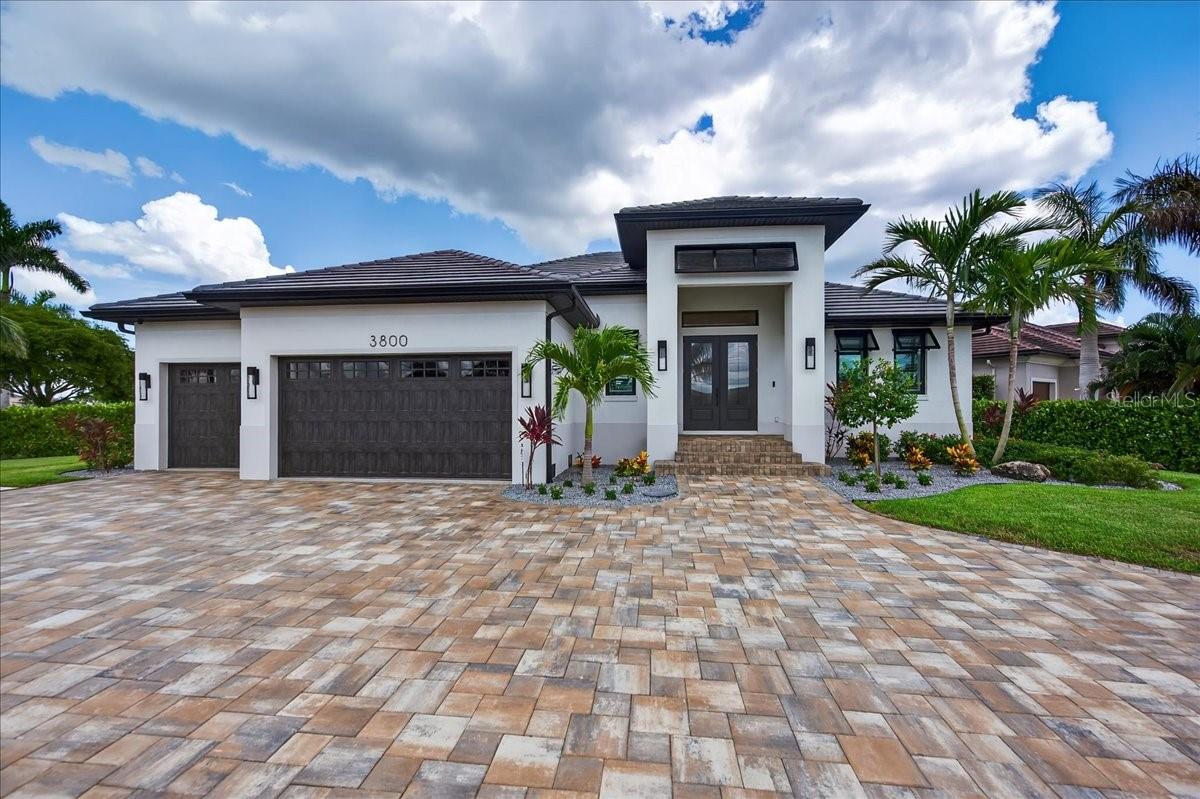 Luxuriously Modern Waterfront Masterpiece in Prestigious Punta Gorda Isles
Welcome to the pinnacle of coastal luxury living—completed in 2024 this custom estate in the coveted Punta Gorda Isles, is where timeless elegance meets cutting-edge innovation. Meticulously curated with no expense spared, this sailboat-access canal-front residence redefines sophistication inside and out. Mere minutes from Charlotte Harbor and the Gulf this home speaks to Location, Location, Location! From the moment you arrive, you’ll be captivated by curb appeal for days with professionally designed landscaping featuring lush Clusia privacy hedges, architectural night lighting, irrigation systems, rain gutters with underground downspouts, and a premium five-course stem wall foundation for ultimate home stability. The stunning circular paver driveway and tongue & groove ceiling entryway set the tone for the grandeur within.
Step through transom-accented French doors into a world of luxury. The open-concept floorplan is anchored by a dramatic coffered tray ceiling in the great room, crowned with custom molding, and flows gracefully into the kitchen and dining area, all providing generous views onto the lanai and pool beyond. At the heart of the home, the chef’s kitchen is a true showstopper—featuring mitered Cambria quartz countertops, ultra luxury GE Monogram appliances, induction cooktop, touch faucets, double-stacked custom cabinetry, a butler’s pantry, and a designer dry bar with dual beverage and wine coolers. Retreat to the primary suite, a serene sanctuary with tranquil water views, a spa-like ensuite featuring a stunning stone soaking tub and matching dual sinks, Cambria quartz surfaces, a Roman zero threshold dual shower, a private water closet, and a beautifully designed custom built walk-in closet. On the opposite wing, two elegant and spacious guest bedrooms and en-suite baths offer luxurious privacy, while a large bonus room serves as a potential 4th bedroom or media lounge. The outdoor space is a true entertainer’s dream. The expansive lanai features an upgraded, heated saltwater PebbleTec pool with sun shelf, remote-controlled Kevlar hurricane screen, and a full outdoor kitchen with direct gas grill hookup—all overlooking the wide canal with sailboat access and your private 10,000 lb boat lift. A beautifully executed tongue and groove wood plank ceiling, elegant pavers and panoramic screens complete this waterfront oasis.
Additional features include:
• Oversized 3-car garage with epoxy floors, built-in shelving, storage systems
• Generac Guardian 22kW whole-home generator
• High-efficiency Trane HVAC, LP tankless water heater, 250-gallon in-ground propane tank
• Hurricane-impact windows & doors
• GE WiFi-enabled laundry system with pedestals
• Built-in surround sound & CCTV security system.
This move-in ready masterpiece blends modern architecture, smart home technology, and luxury finishes in one of Southwest Florida’s most exclusive waterfront communities. Minutes to Saint Andrew’s Golf course, The Isles Yacht Club, the famous Fisherman’s Village, restaurants, cafes, shopping, and so much more. Enjoy everything Punta Gorda has to offer. Don’t miss this Diamond! Call today for a private showing.