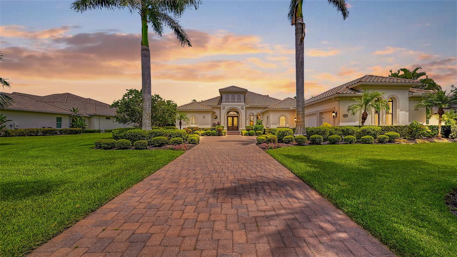 Set on a rare one-acre homesite in the prestigious Concession Golf & Country Club, 8361 Lindrick Lane captures the essence of refined Florida living. Boasting a premier orientation—with tranquil lakefront sunsets at the front and a private preserve backdrop to the rear—this property offers an unparalleled sense of serenity and privacy. The generous open plan blends elegance and comfort, showcasing 12-foot ceilings, wide-plank engineered flooring, and a striking stone feature wall with fireplace—elevating the home’s timeless sophistication. Designed for both daily living and memorable entertaining, the home offers three bedrooms, three full baths, a custom office filled with natural light, and a versatile bonus/media room. The chef’s kitchen is a centerpiece, featuring an impressive quartz island, natural gas cooking, built-in appliances, and seamless flow into the great room. Expansive pocketing sliders and a dramatic disappearing corner of glass open the interiors to the lanai, blurring the lines between indoor comfort and outdoor entertaining. The sweeping lanai serves as a private oasis, with a heated pool and spa, a fully equipped outdoor kitchen, multiple dining and lounge areas, and space for a firepit beneath the stars. The primary suite is a luxurious retreat with French doors to the pool terrace, oversized walk-in closets, and a spa-inspired bath. A three-car garage and thoughtful finishes throughout further enhance this exceptional property. Constructed in 2015 and located outside of a high-risk flood zone, this residence offers both elegance and peace of mind. Renowned for its championship golf (available through optional membership), the Concession has hosted prestigious PGA Tour events including the 2021 World Golf Championships and the 2023 World Champions Cup, complemented by celebrated wine-focused dining and serene natural beauty. Ideally located in Lakewood Ranch, near luxury shopping, fine dining, and Sarasota’s finest Gulf Coast beaches, this residence offers the perfect blend of exclusivity and connection.