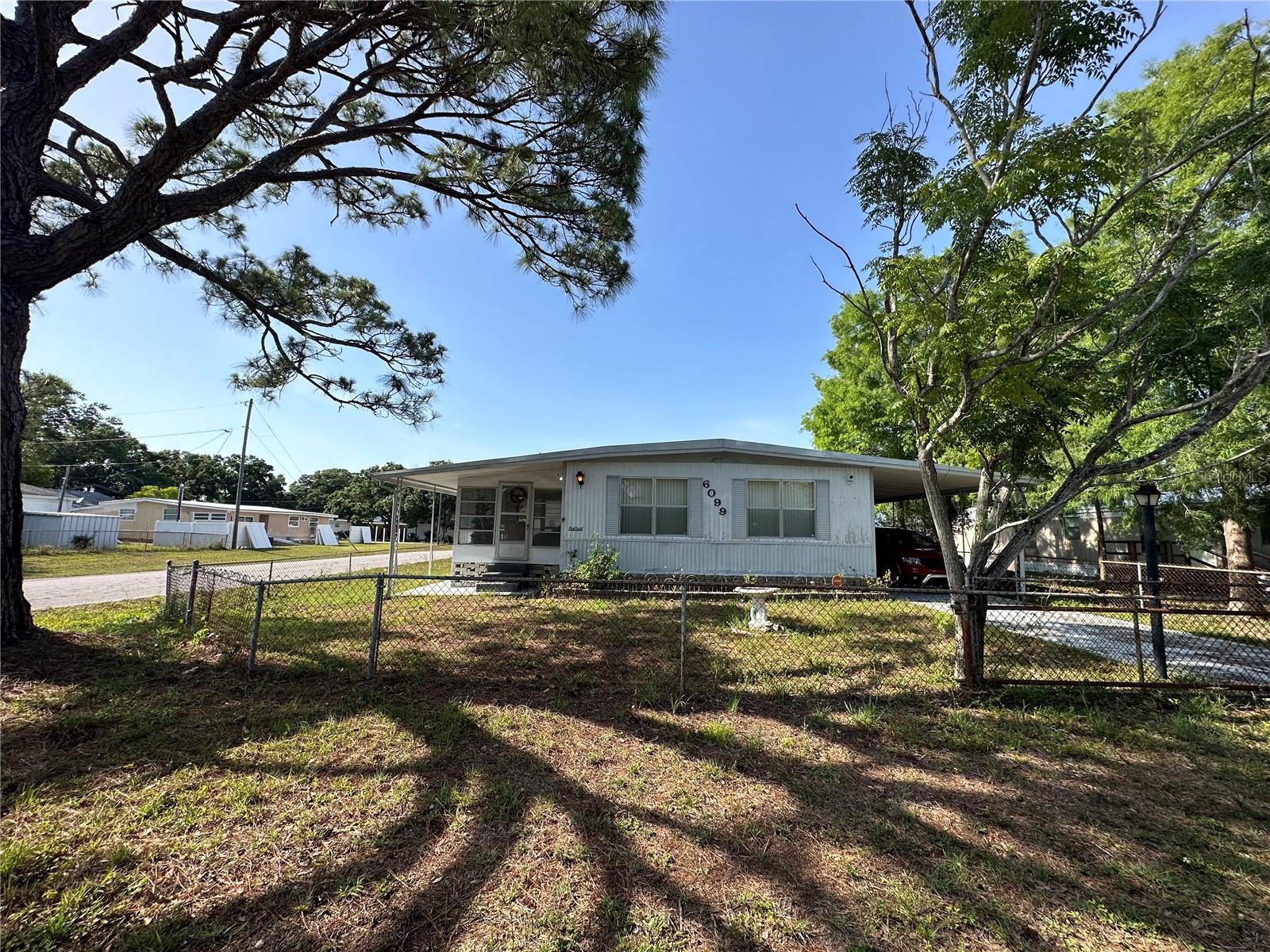 No HOA, No Lot Rent. You OWN the LAND! Spacious Double Wide on Fenced Corner Lot – No HOA, No Deed Restrictions
This well-located double wide mobile home offers space, flexibility, and opportunity—perfect for investors, flippers, or handy buyers looking to customize and add value. Situated on a fully fenced corner lot with no deed restrictions and no HOA fees, this property provides freedom to bring your RV, boat, or extra vehicles, thanks to a covered carport and additional parking pad.
Inside, the home features a large kitchen with a natural gas stove, breakfast bar, pantry, and ample cabinet space. The adjacent dining area includes built-in storage, while the open layout provides plenty of potential for updates and personalization.
The primary suite includes two closets, a handicap-accessible shower, and a separate vanity area. Additional features include:
Screened side lanai for relaxing or entertaining
Two storage sheds for tools and equipment
Updated windows in select areas
AC and fully updated electrical system (2021)
Conveniently located near US-19 and public transportation, this home offers easy access to Tampa, Clearwater, St. Petersburg, as well as nearby parks, shopping centers, beaches, and recreation.
Whether you're seeking your next investment or an affordable home with room to grow, this property offers excellent value and potential. Schedule your showing today.