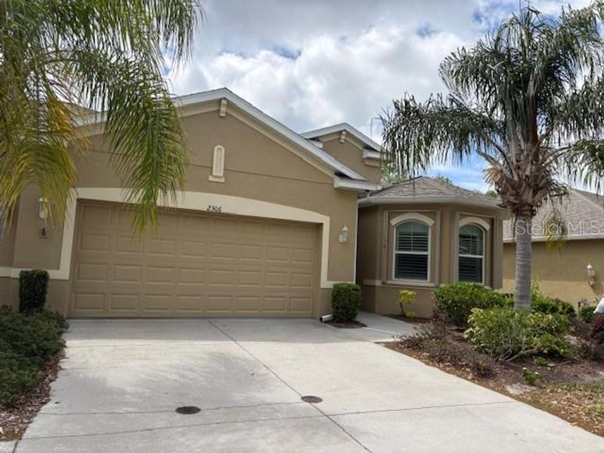 This charming, three bedroom, Magnolia model has many upgrades. These include, kitchen cabinets, quartz counter tops and under counter lighting! Lving room has tray ceiling and crown molding.  It is nicely decorated with windows blinds and designer drapes.Both bathrooms have granite counter tops.  The master bath has customized pull out baskets and large unique walk in shower. The glassed in Lanai has ceramic tile and a private back yard. A new air conditioner installed in 2024. The two car garage will easily fit you car and a golf cart. The owner has recently had easy close sliding hurricane shutters on most windows, as well as protective easy to install panels for the Lanai.
Located centrally in the the community, close by the South Club House where you will enjoy the restauant,inside and ootside pools , fitness center, pickle ball courts and SO much more.