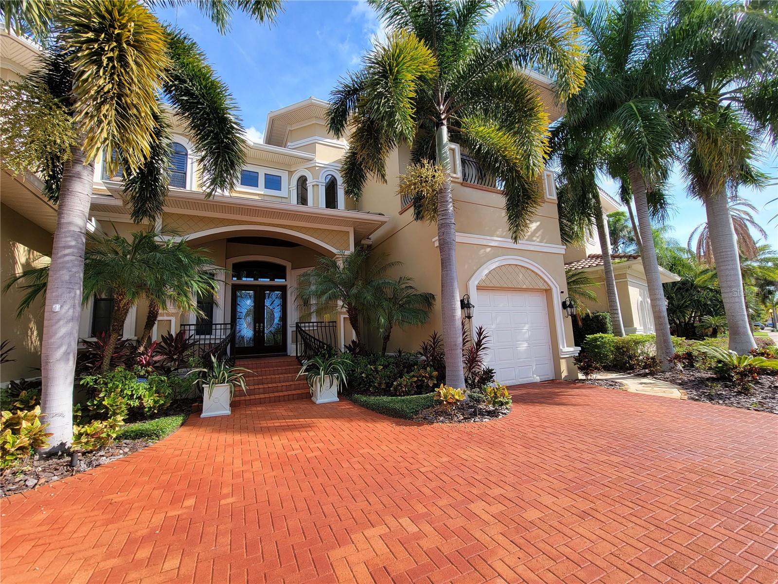 Welcome to Tampa Bay’s most desired gated waterfront community: The Reserve of Old Tampa Bay. This quiet enclave showcases some of the most breathtaking sunrises and sunsets on Florida’s West Coast. Surrounded by lush palms, private water access, and serene views of Old Tampa Bay, this home offers a rare blend of tranquility and luxury living.
Custom-built in 2006 by Alvarez Homes, this residence makes a statement the moment you arrive. Double custom entry doors open to a soaring foyer illuminated by a crystal chandelier. To the left, an elegant formal dining room sets the stage for memorable gatherings, while the formal living room offers floor-to-ceiling bay views and a Baby Grand player piano as its centerpiece. The first floor hosts a mini-owner’s suite with patio and pool access, an ensuite bath, and walk-in closet—ideal for guests or multi-generational living. A powder room features a striking floor-to-ceiling Florida mural, while a private entrance to the one-car garage offers convenience and privacy.
The chef’s kitchen is fully outfitted with luxury appliances: Wolf gas cooktop, Bosch convection oven, Profile microwave, Sub-Zero refrigerator, built-in wine chiller, and Bosch dishwasher. Custom cabinetry complements granite counters and an expansive island. Nearby, the laundry room provides access to a two-car garage with custom lift, tankless water heater, water softener, and reverse osmosis systems.
The open-concept family and dining area boasts custom built-ins framing the entertainment center and an in-house audio system. Pocketing glass sliding doors can be opened fully, blending indoor comfort with outdoor living.
Stepping out onto the expansive patio, you can't help but take in the front-row bay views. Entertain or relax beside the private saltwater pool or dip into the heated spa with its cascading waterfall. A poolside half-bath and sauna add resort-level convenience. The outdoor kitchen—complete with gas grill, granite bar, and counter seating—makes alfresco dining effortless. After dinner you may want to access your boat from your own private boat lift and tour the bay.
Back inside, ascend the chandelier-lit elevator and marvel at the endless tall ceilings as you exit onto the dramatic catwalk. Two guest suites feature walk-in closets, a shared Jack-and-Jill bath, and private balconies. On the other side of the catwalk you will find a spacious loft and bonus room that holds a secret entry to walk-in closet of the primary suite, where a spa-inspired bathroom awaits with separate vanities, two private water closets, a deep jetted soaking tub, and a large walk-in shower.
The Reserve of Old Tampa Bay is just minutes from Downtown Tampa, the Gulf Beaches, and Tampa International Airport. Offering both privacy and proximity, it is truly the best of both worlds.
A home of elegance, comfort, and unforgettable views—this is where your next chapter begins.