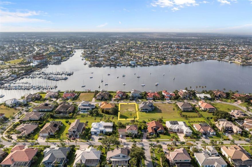 Opportunities like this don’t come around often in Andalucia—one of the most exclusive gated waterfront communities in Apollo Beach. This oversized .41-acre lot (100 x 180) sits quietly on the interior of Rubia Circle. Even though it’s not directly on the water, you can still see and hear the harbor, which adds a calming backdrop to the setting.

Andalucia isn’t your average neighborhood. Residents here enjoy 24/7 manned gate security, a private marina and yacht club, bayfront clubhouse with pool and sweeping views of Tampa Bay, lighted tennis courts, a fishing jetty, basketball court, playground—the list goes on. Hop on your boat for a quick trip to Beer Can Island or just unwind with sunset views over the bay. This is a true waterfront lifestyle.

The location also puts you minutes from Apollo Beach’s best waterfront dining, golf, nature preserves, and easy access to I-75. Whether you're commuting to Tampa, St. Pete, or Sarasota, you're well-positioned for it all.

If you’ve been waiting for the right lot to build something special, this is it. Very few buildable lots are left in Andalucia—and certainly not with this mix of space, privacy, and amenities. Don’t let it slip away.