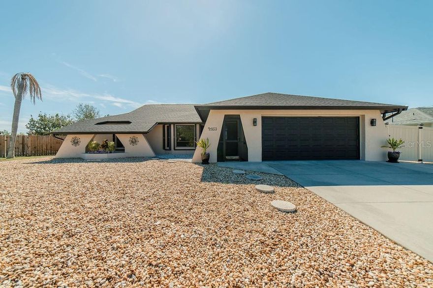 Welcome to this beautifully maintained 2 bedroom, 2-and-a-half bathroom home offering 2,126 SF of living space and an inviting open floorplan, perfectly situated in Flood Zone X with NO HOA. A new roof (2023), along with an HVAC system and water heater less than 5 years old, provide peace of mind and long-term value.  The exterior showcases attractive rock landscaping surrounding the entire home, enhancing curb appeal and low-maintenance living. Inside, you’ll find a spacious primary suite with a LARGE walk-in closet, an ADT security system, and a utility room complete with a wash tub for added convenience.  One of the standout features is the HUGE Florida room, lined with curved windows reaching toward the sky—all operable with screens to invite in refreshing breezes. This space also offers direct access to a convenient half-bath, making it ideal for entertaining. Additional highlights include an enclosed screened front porch, accordion-style hurricane shutters, and a fully fenced private backyard with a storage shed and outdoor shower.  The 2-car garage is complemented by extra parking space ideal for a boat or RV. Located just minutes from Ann & Chuck Dever Regional Park pool, and close to the charm of Dearborn Street, local beaches, golf courses, shopping, and dining, this home offers the best of Florida living—privacy, convenience, and lifestyle all in one exceptional package.