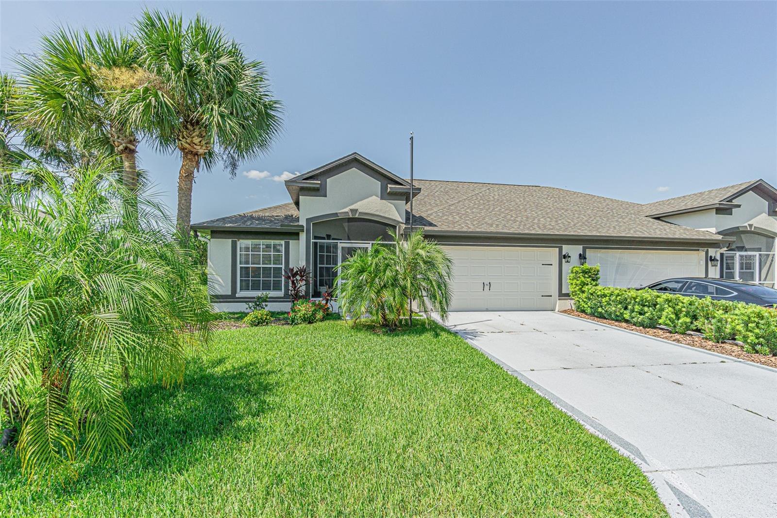 WELCOME TO FLORIDA living at its best! This beautifully maintained, BETTER THAN NEW, maintenance-free villa is perfectly situated on the 18th hole of Tampa Bay Golf & Country Club, offering gorgeous golf course views without the worry of golf balls in your yard! Featuring a desirable open floor plan, this home flows from the Screened front entry thru the Foyer and great room to the screened lanai... an ideal spot to enjoy morning coffee, evening meals, or spectacular sunsets over the fairway. The updated kitchen features granite countertops, a breakfast bar, stainless steel appliances (2021), pantry, and dinette with large window boasting golf course views and direct lanai access thru the sliding doors. The spacious great room showcases volume ceilings and sliding glass doors that bring in abundant natural light while extending your entertaining space on the extended Florida room with Spectacular Sunsets! The split-bedroom layout provides privacy, with Primary bedroom at the rear of the home with bath ensuite with new shower floor and large double window in bedroom with golf course views. LVP flooring, fresh interior and exterior paint (2025), and sleek decor add a modern feel. Additional upgrades include a NEW ROOF (2025), new garage door opener motor (2025), extended Florida room with tile floors and slider windows, attic stairs in garage, epoxy-coated garage, driveway and front walkway, custom shelving in the 2 car garage for storage plus a water filtration system. Inside laundry room is equipped with washer and dryer, with storage above. All window treatments stay and the home is wired for security with an in-wall pest control system for peace of mind. Enjoy the RESORT lifestyle you deserve in this active 55+ gated community with resident owned amenities including tennis, pickleball, shuffleboard, cornhole, bocci, horseshoes, clubhouse, full service restaurant, pub grille, ballroom and banquet facilities, library, fitness center, activities center, 2 swimming pools, game rooms with poker tables, billiards, card tables, planned activities, onsite entertainment and travel excursions available! Basic cable with 2 boxes, high speed internet, wi-fi, irrigation, and lawn care are included in the HOA fee, making this home truly low-maintenance. Ideally located near major highways for easy commute to premium shopping, dining, medical facilities, airports and to Florida’s world-famous Gulf beaches... this villa is the perfect place to call home. CALL TODAY!