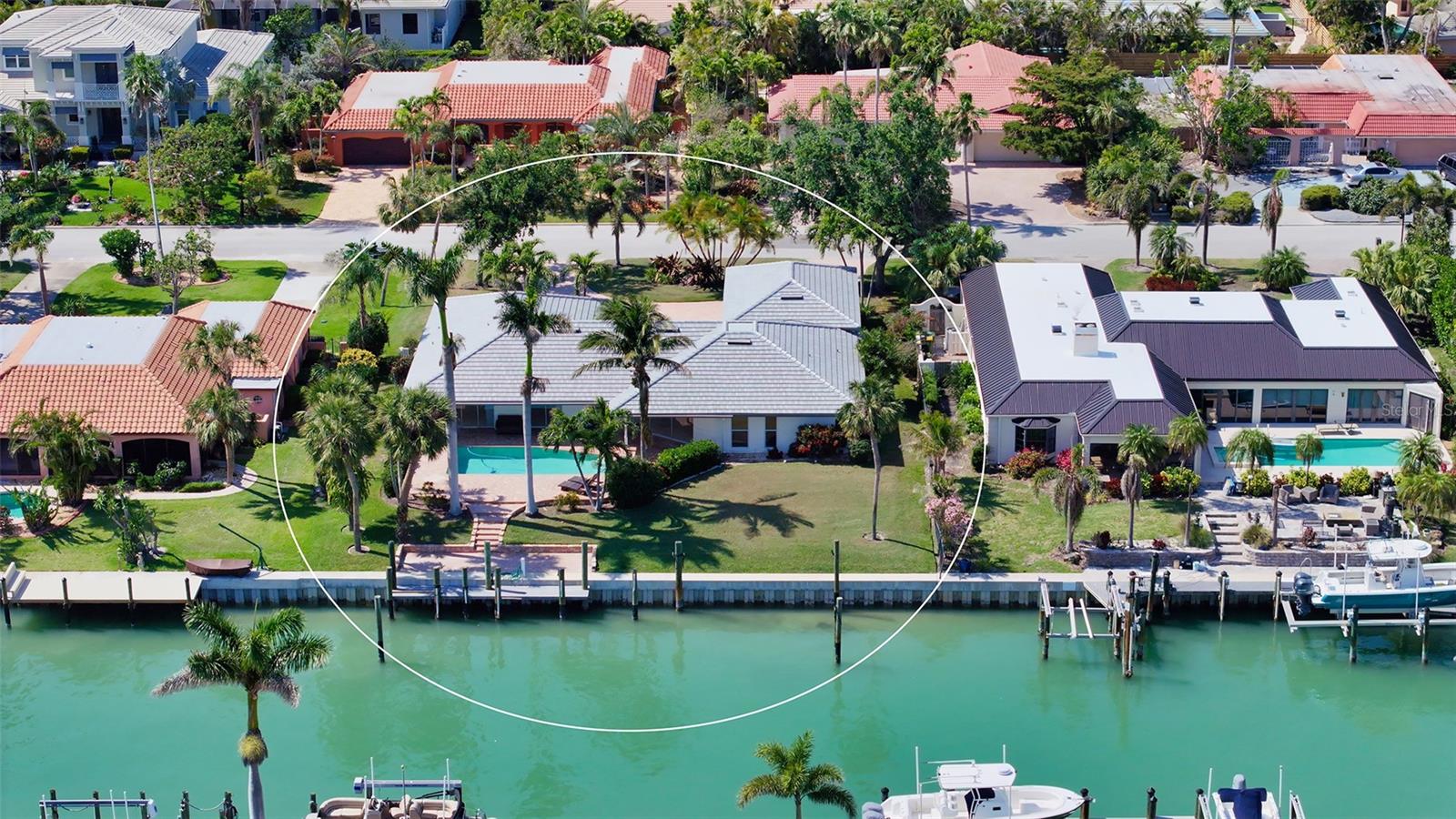 One or more photo(s) has been virtually staged. Perfectly positioned on deep canal waters just moments from Sarasota Bay, this Bird Key residence captures the essence of relaxed coastal living. Set on a generous lot and framed by tropical landscaping, this home blends privacy with proximity to Sarasota’s vibrant downtown and waterfront destinations. A circular brick-paver driveway leads to the welcoming front entry, while a brand-new roof (2024) offers peace of mind. Inside, more than 2,100 square feet of light-filled living space unfolds across an open, thoughtfully designed floorplan. Neutral oversized tile flooring flows throughout the main living areas, unifying the open-concept kitchen, family room, and dining spaces. The kitchen boasts granite countertops, sleek cabinetry, stainless steel appliances, a breakfast bar, and expansive counter space—ideal for both daily living and effortless entertaining. Walls of sliding glass doors extend the living area out to the screened lanai, where a covered lounge and pavered deck frame the sparkling pool. The residence features three spacious bedrooms, including a private primary suite with large walk-in closet and a en-suite bathroom. The home’s split-bedroom layout ensures comfortable accommodations for guests, while ample storage and a generous laundry area add everyday functionality. A newly rebuilt seawall (2022) and deep-water dock provide direct access to Sarasota Bay, making this a true boater’s retreat. Enjoy morning coffee or sunset cocktails with tranquil canal views just steps from your back door. Bird Key is one of Sarasota’s most sought-after neighborhoods, prized for its central location, manicured streets, and strong sense of community. Residents enjoy proximity to the Bird Key Yacht Club, with optional membership for boating, tennis, fitness, and dining. Just minutes away are the world-class shopping and dining of St. Armands Circle, pristine beaches of Lido and Longboat Key, and Sarasota’s thriving arts and cultural district.
This residence offers an opportunity to live on the water with generous indoor and outdoor spaces—perfect for savoring the Florida lifestyle in style and comfort.
